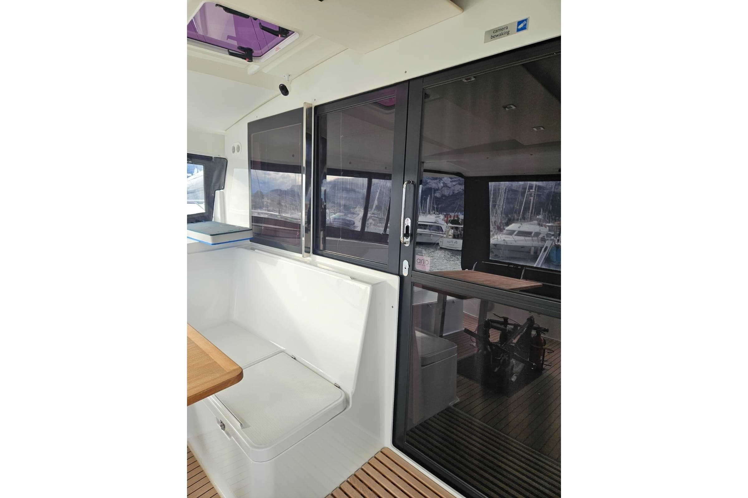 Interior view of 2022 Fountaine Pajot Isla 40 catamaran with seating and sliding glass doors.