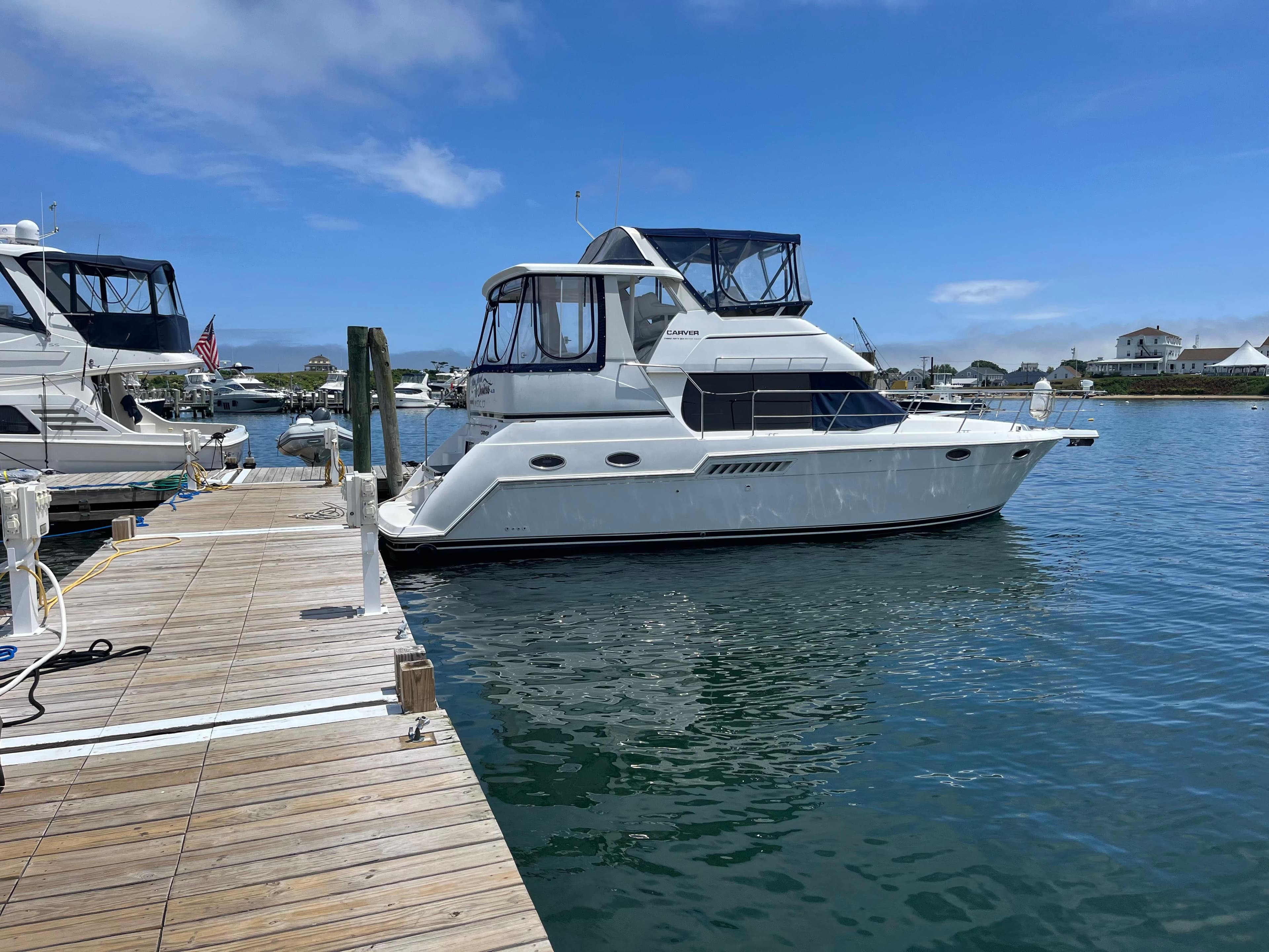 2001 Carver 356 Aft Cabin Motor Yacht docked in a marina under clear blue skies.