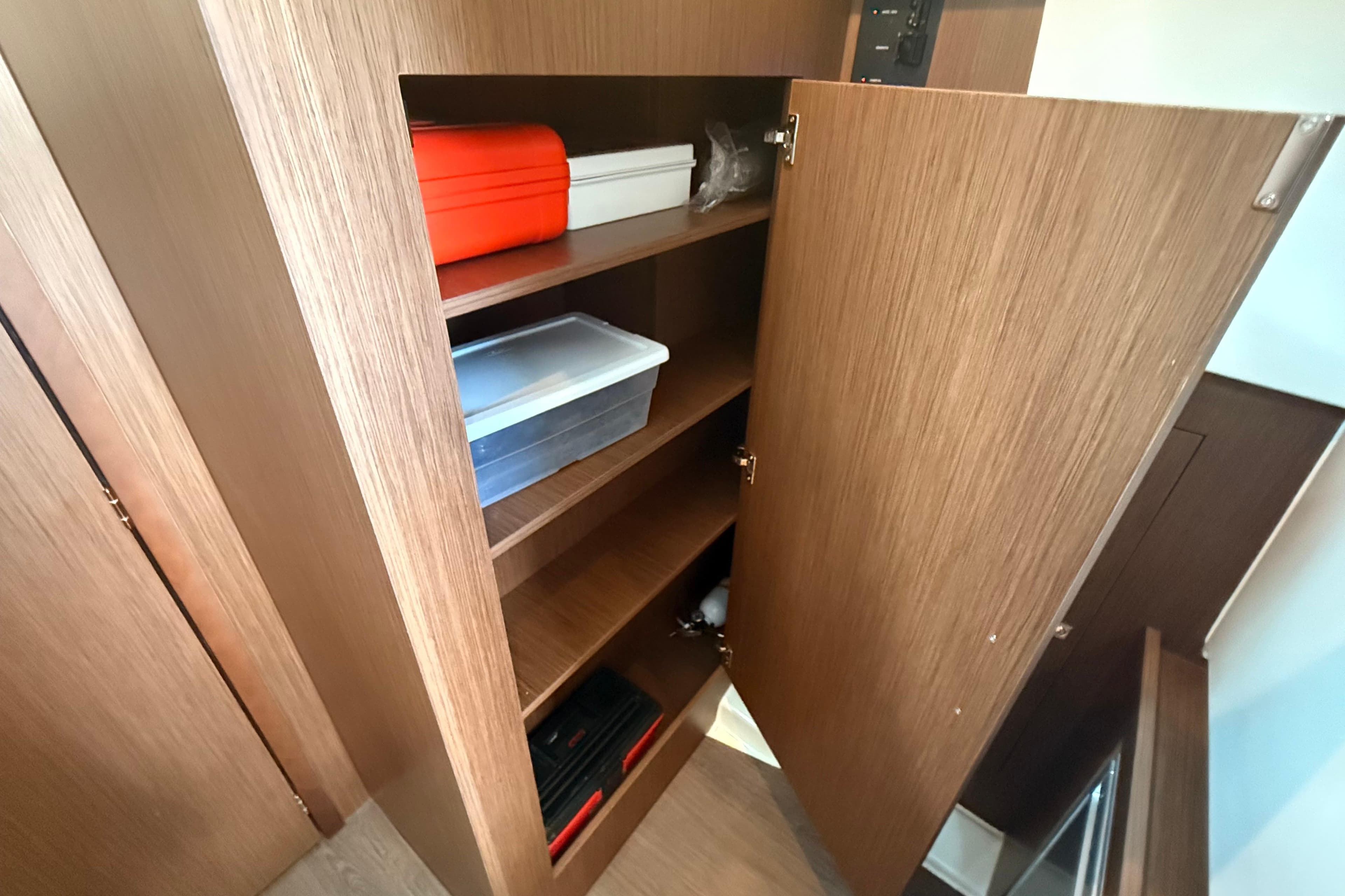 Open wooden cabinet with shelves on 2024 Beneteau Antares 11 boat.