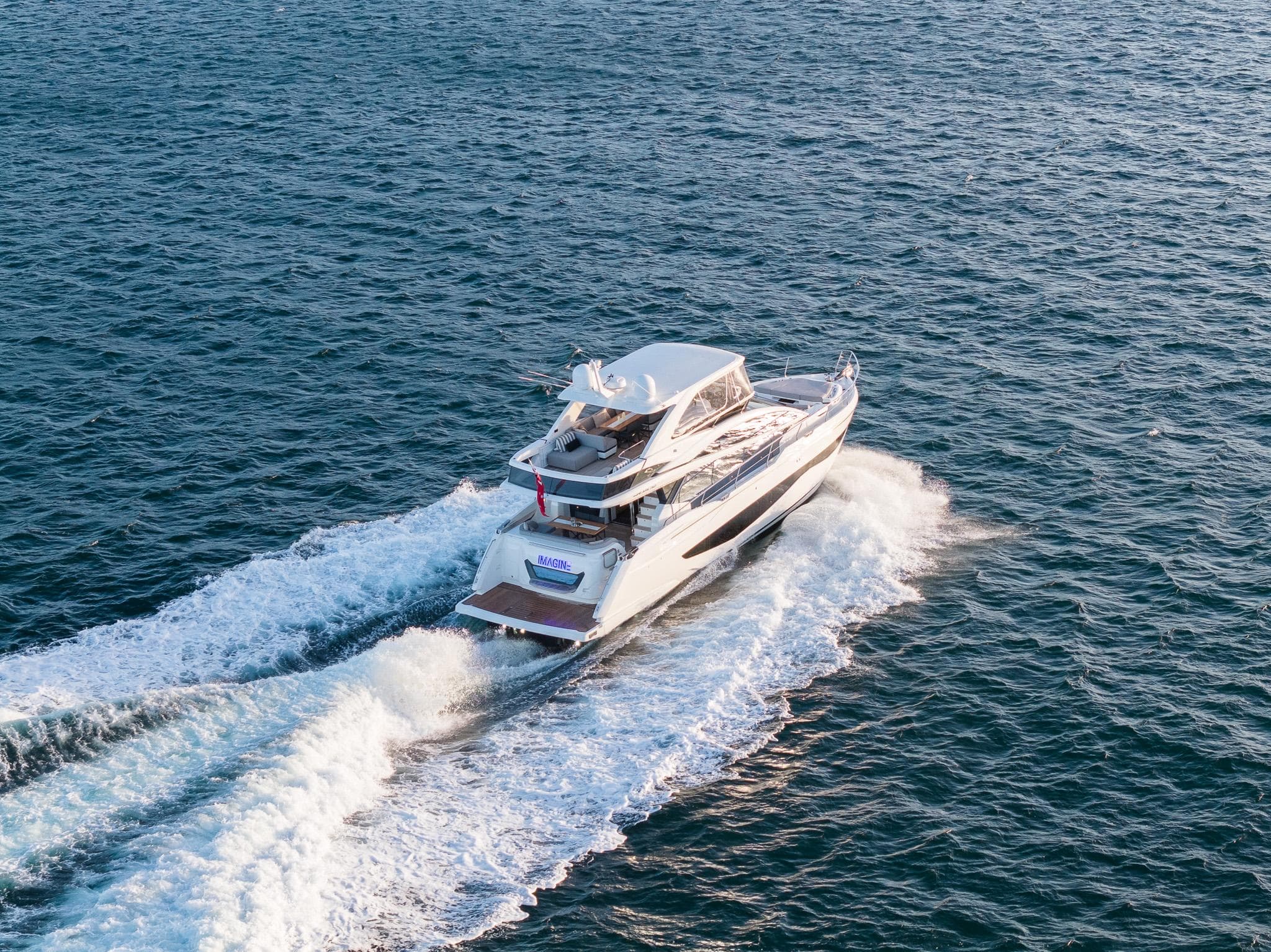 2023 Pearl 62 yacht cruising on open water, creating a wake.