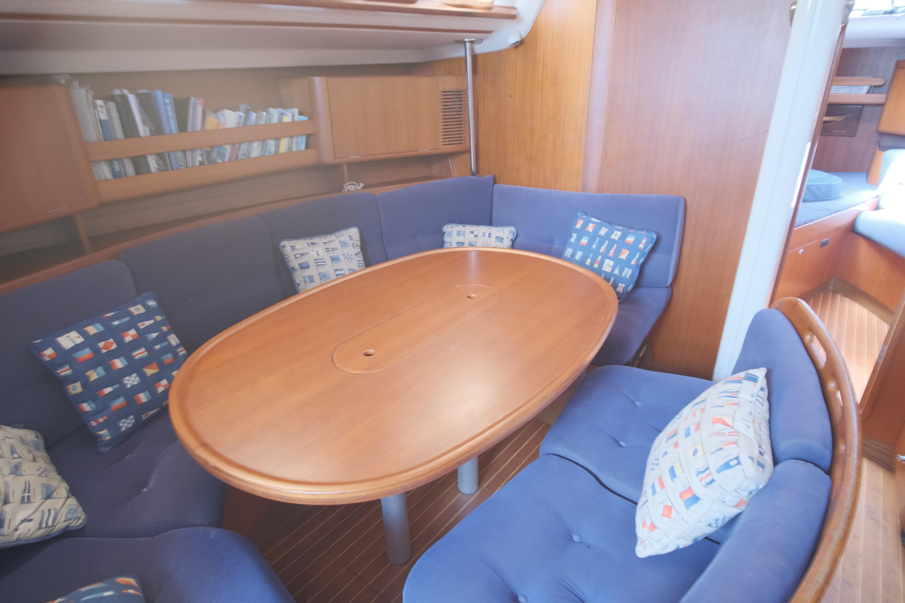 Interior of 2000 X-Yachts 442 MK II with blue seating and wooden table.