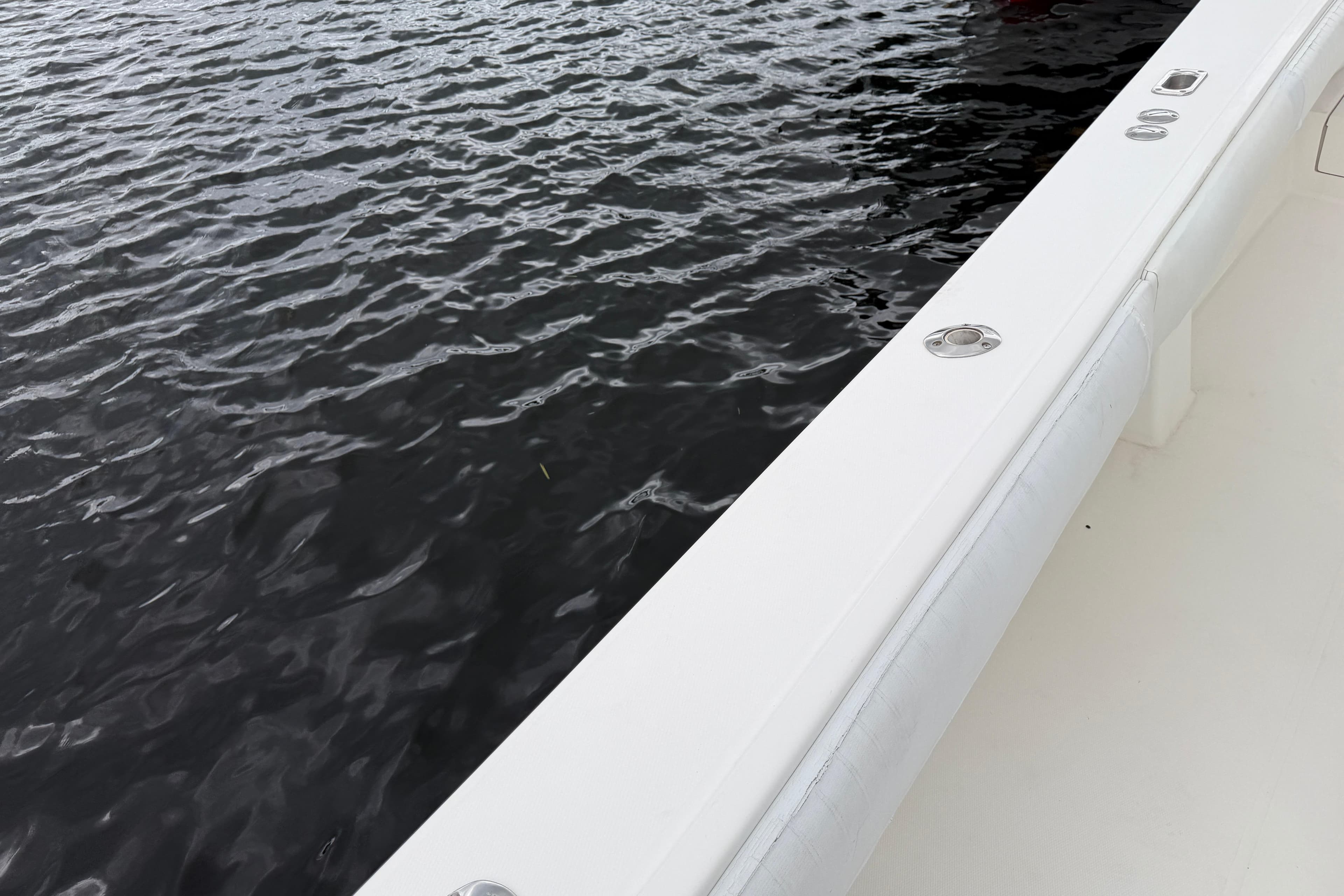 2002 Regulator 32 Forward Seating boat on water, showcasing sleek white design.