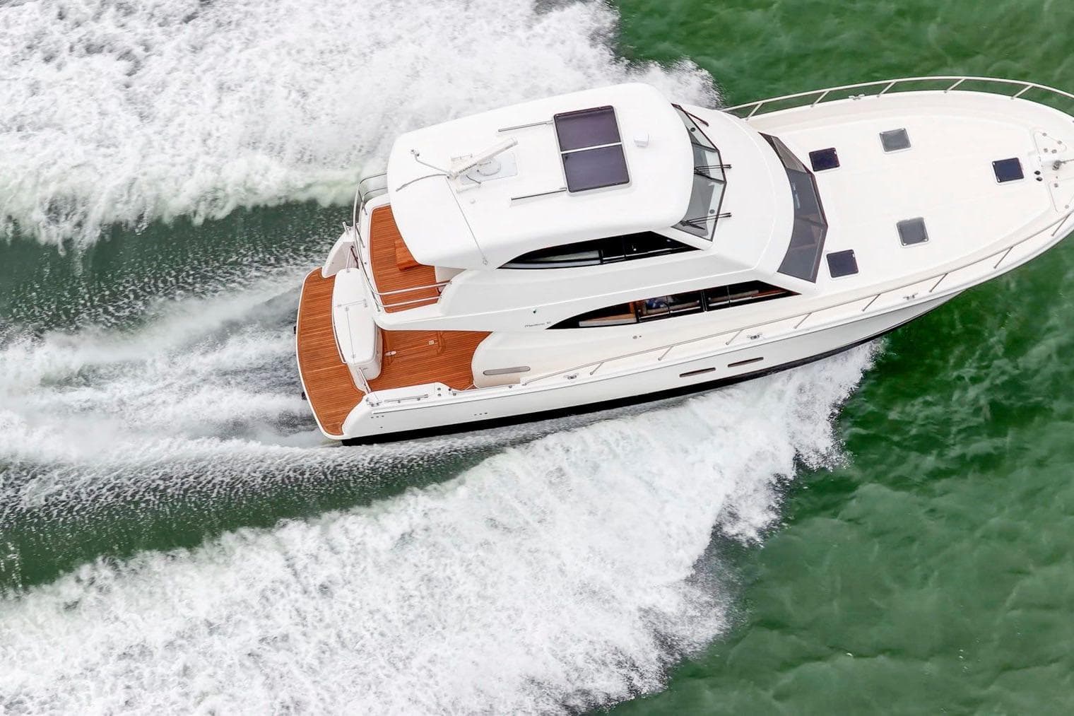 2014 Maritimo M50 yacht cruising on green water, aerial view.
