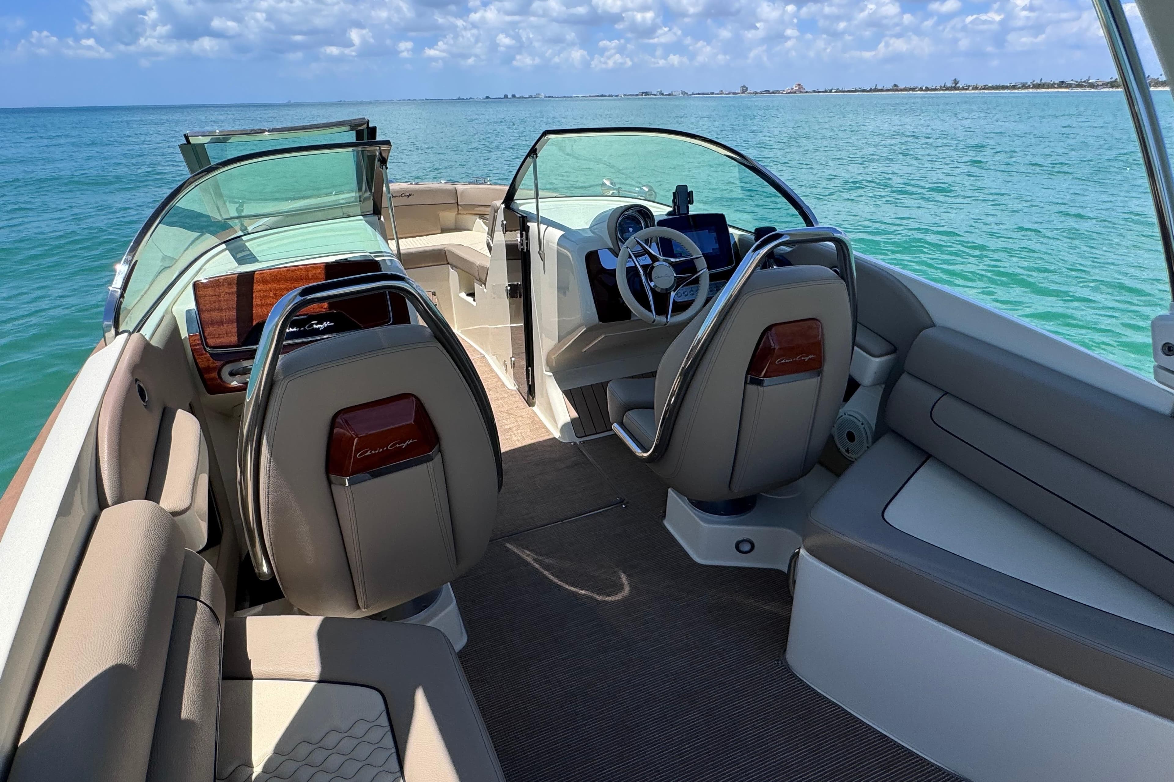 2023 Chris-Craft Launch 25 GT interior with luxurious seating and steering, overlooking the ocean.
