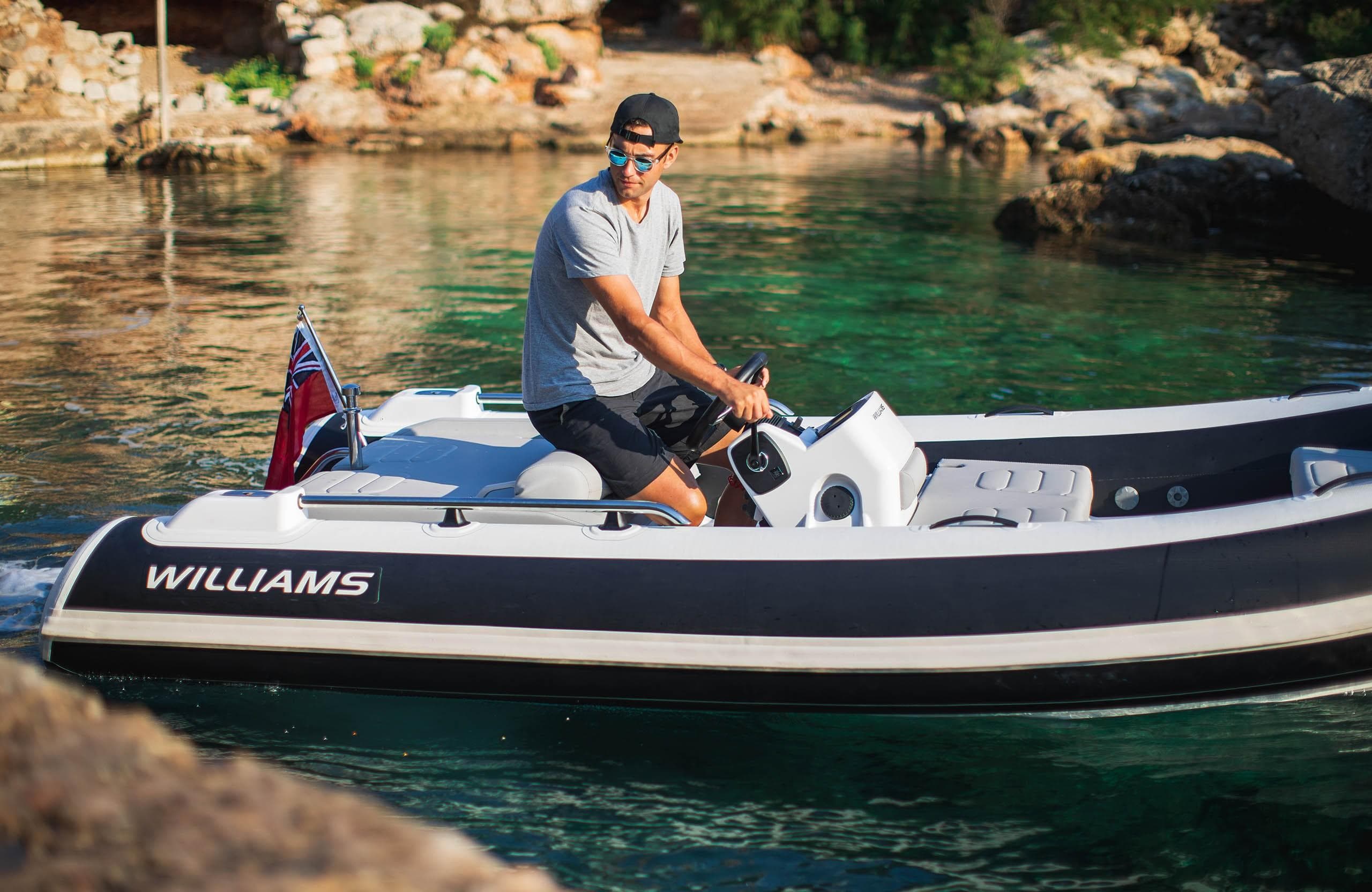 Man driving 2025 Williams Jet Tenders Sportjet 435 on clear water.