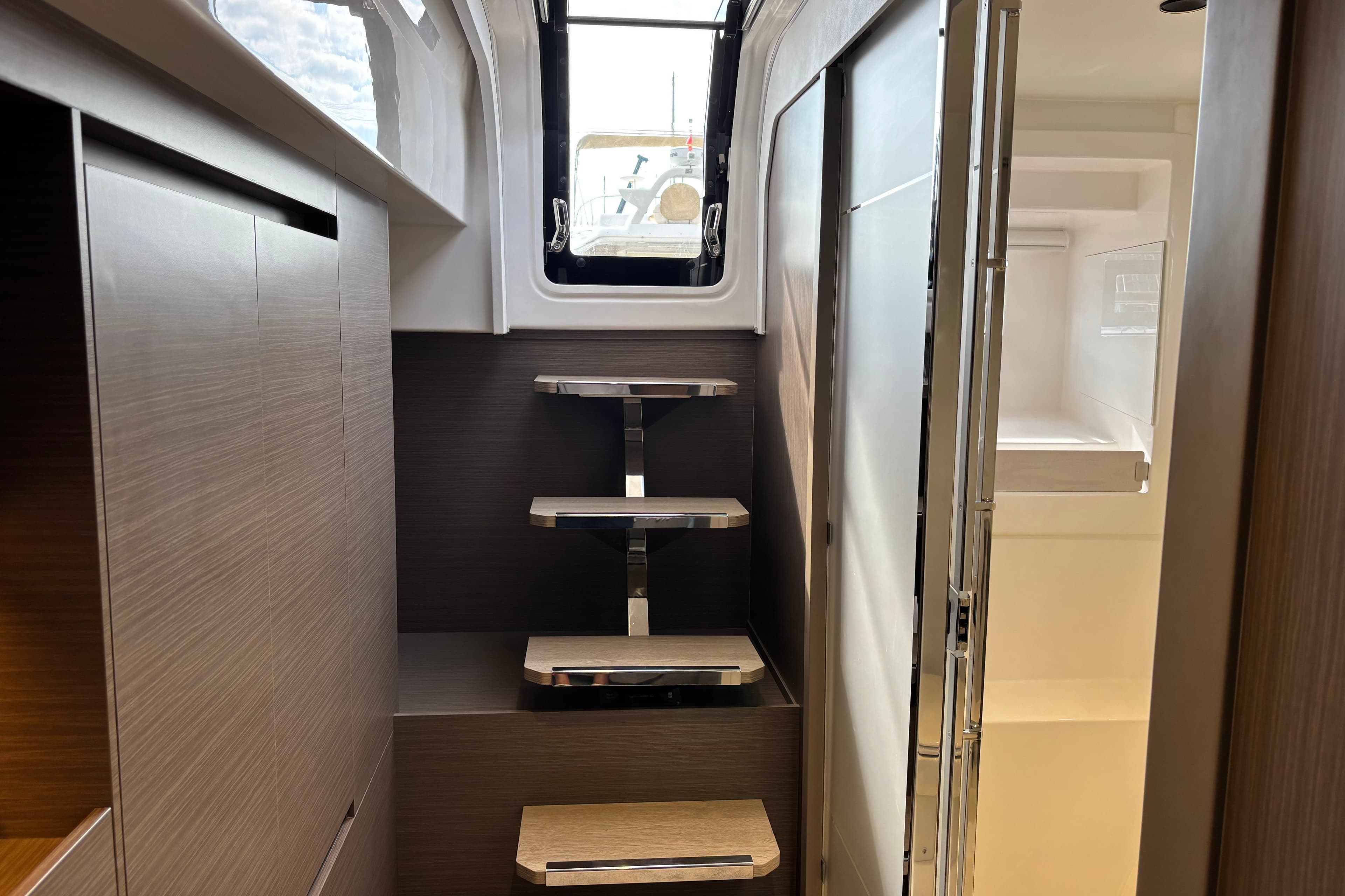 Interior of 2025 Leopard 52 yacht with modern wooden cabinetry and sleek staircase.
