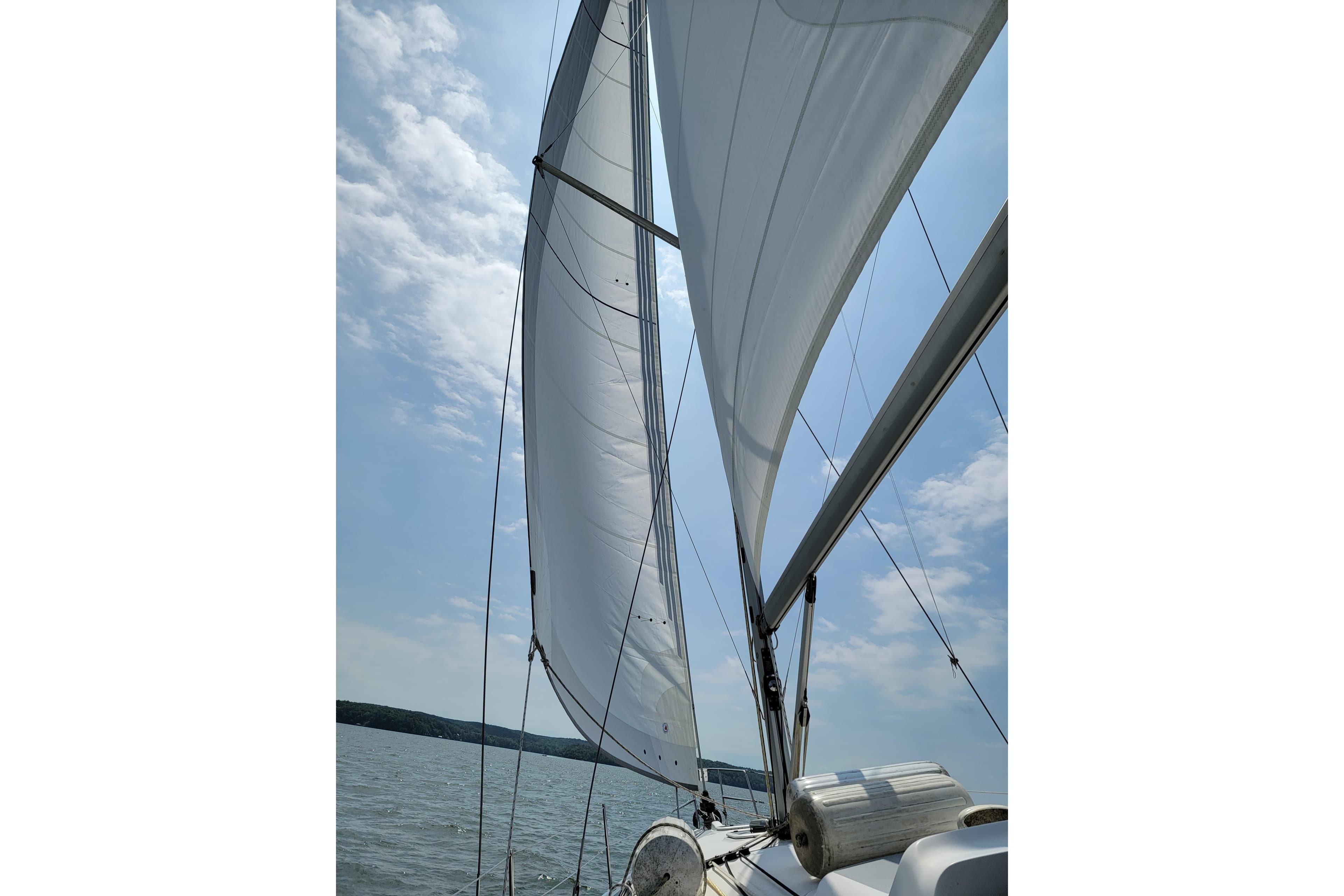 Sailing on a 2004 Hunter 41 AC yacht with full sails under a clear sky.
