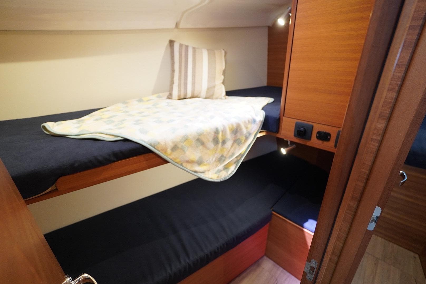 Bunk beds in 2022 Elan IMPRESSION45.1 yacht cabin with cozy bedding and wooden interior.