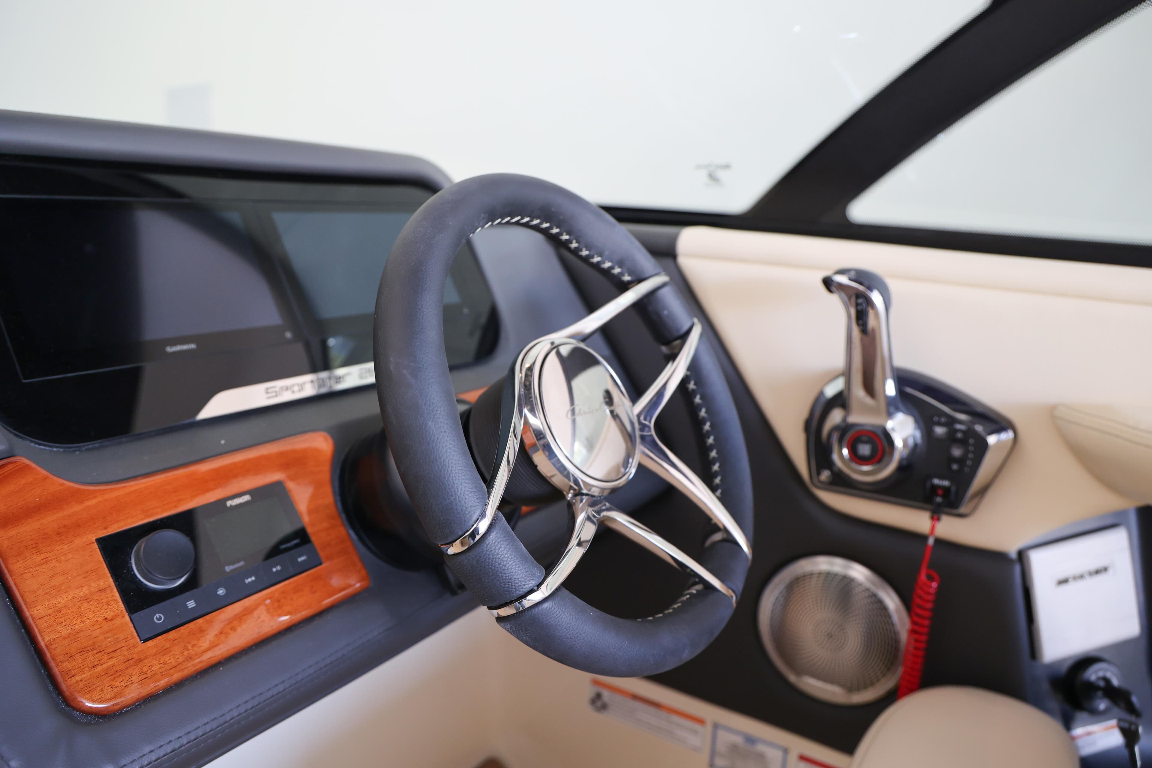 Interior of 2026 Chris-Craft Sportster 28, featuring sleek steering wheel and modern controls.