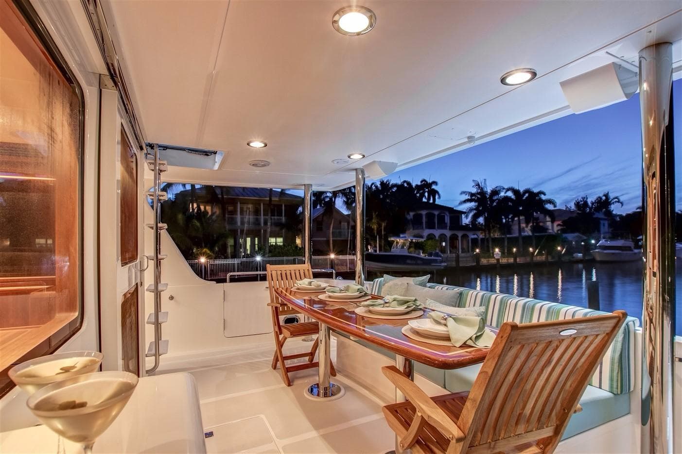 Luxurious 2027 Outer Reef Yachts 610 Motoryacht deck with elegant dining setup at sunset.