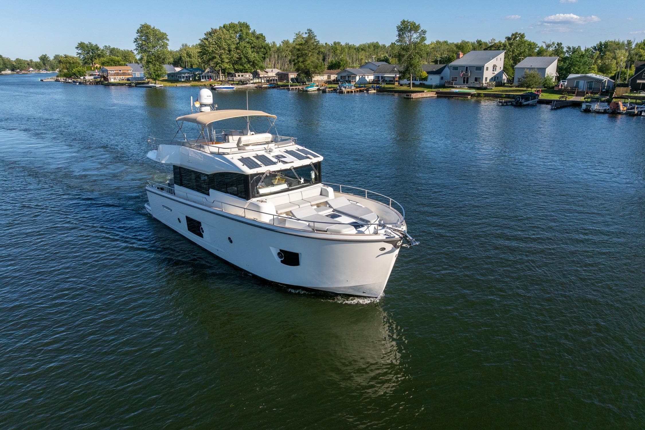 2018 Cranchi Eco Trawler 53 Long Distance cruising on a serene lake near waterfront homes.