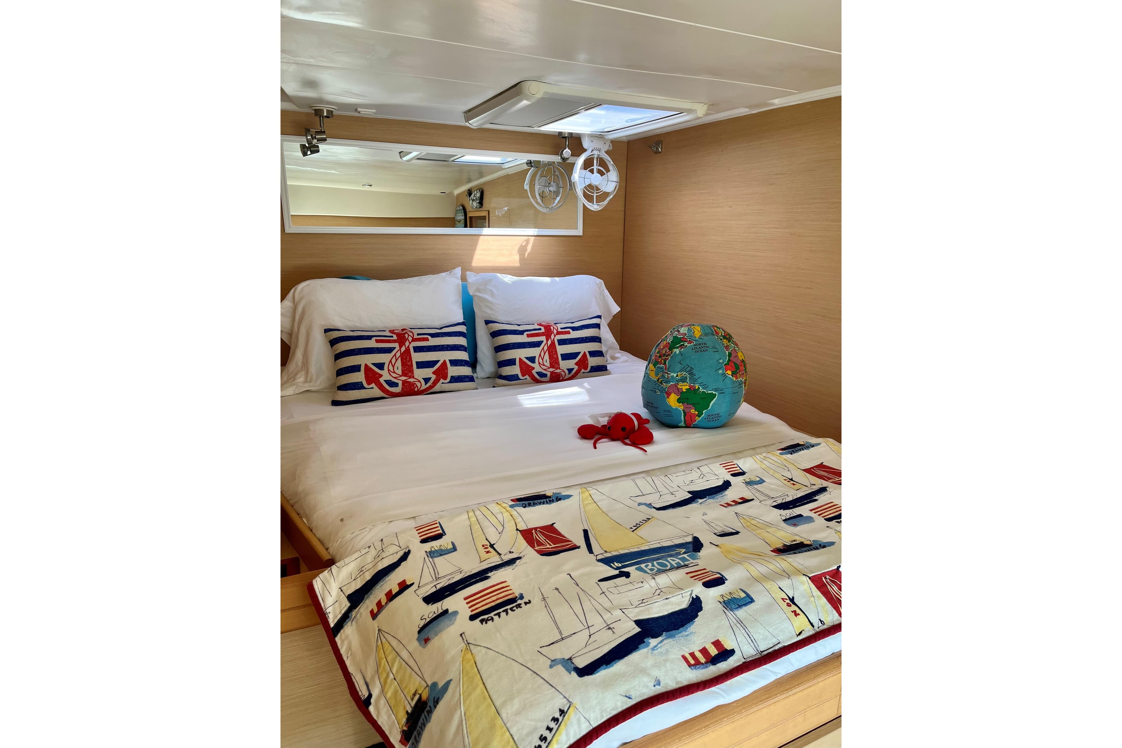 Cozy cabin bedroom in 2008 Lagoon 420 yacht with nautical decor and globe.