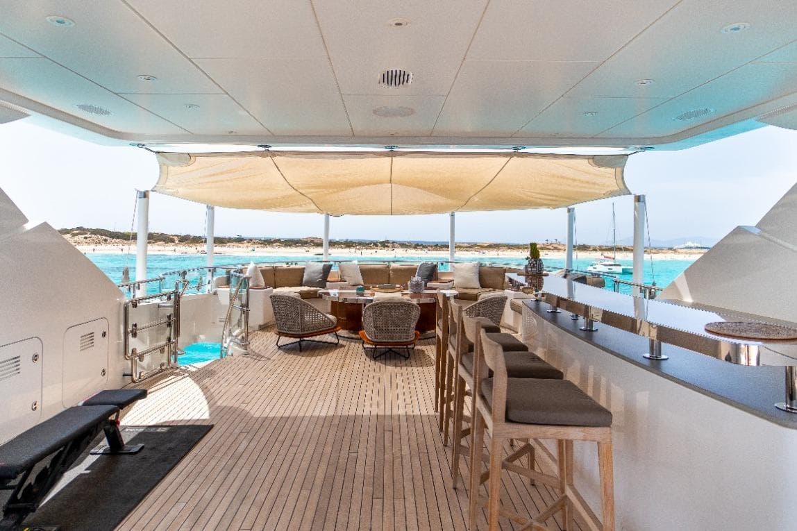 Luxurious 2015 Heesen 47 yacht deck with bar, seating, and ocean view.