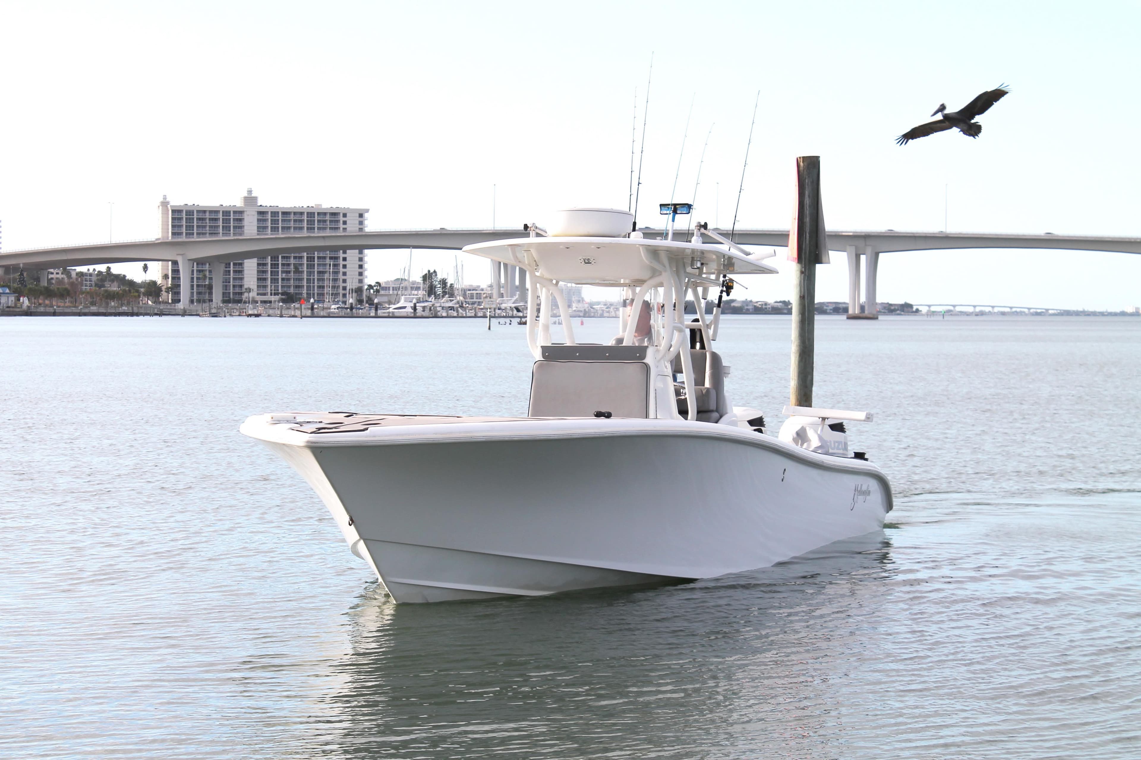 2005 Yellowfin 31 Center Console boat on calm water near a bridge.