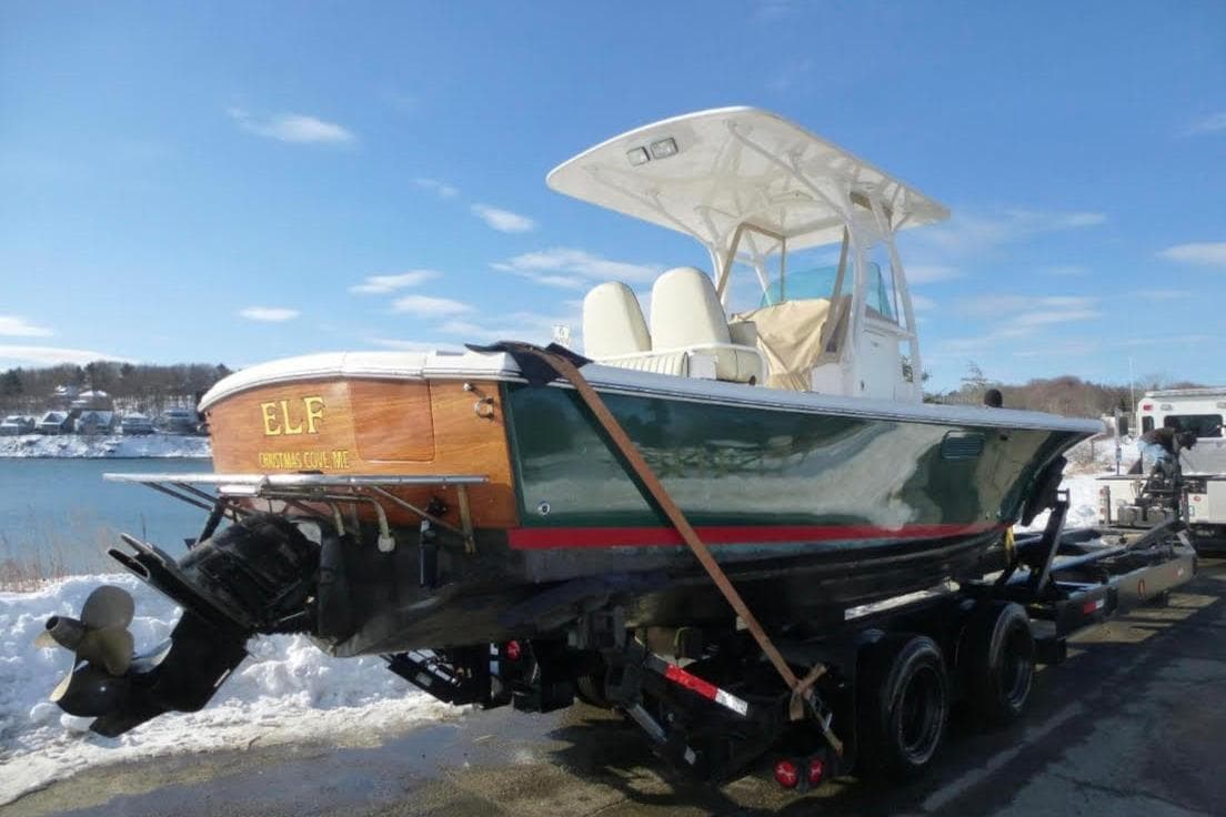 2008 Hunt Yachts Surfhunter 25 Center Console on trailer by snowy waterfront.