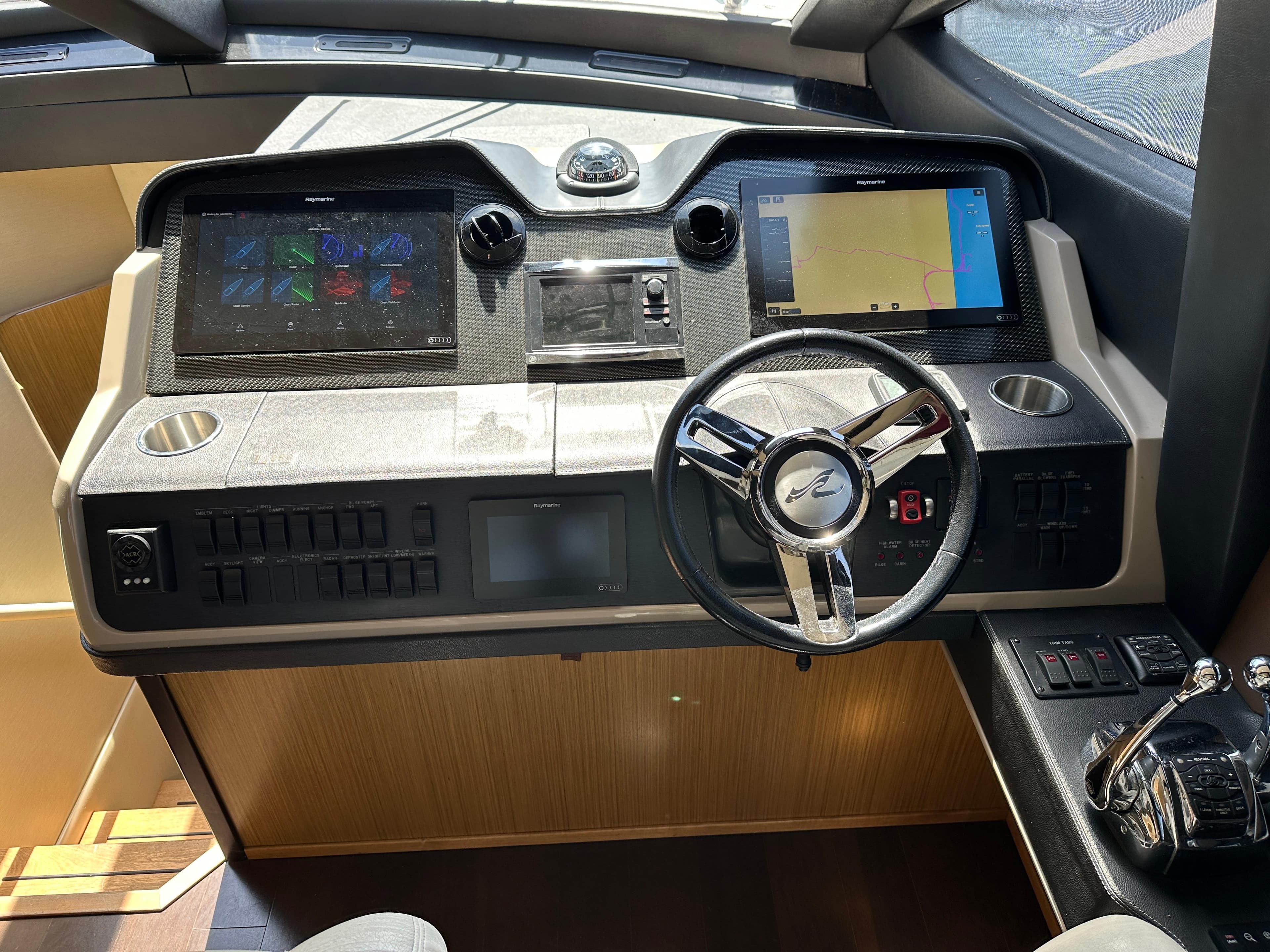 Helm of 2016 Sea Ray L590 yacht with modern navigation controls and steering wheel.