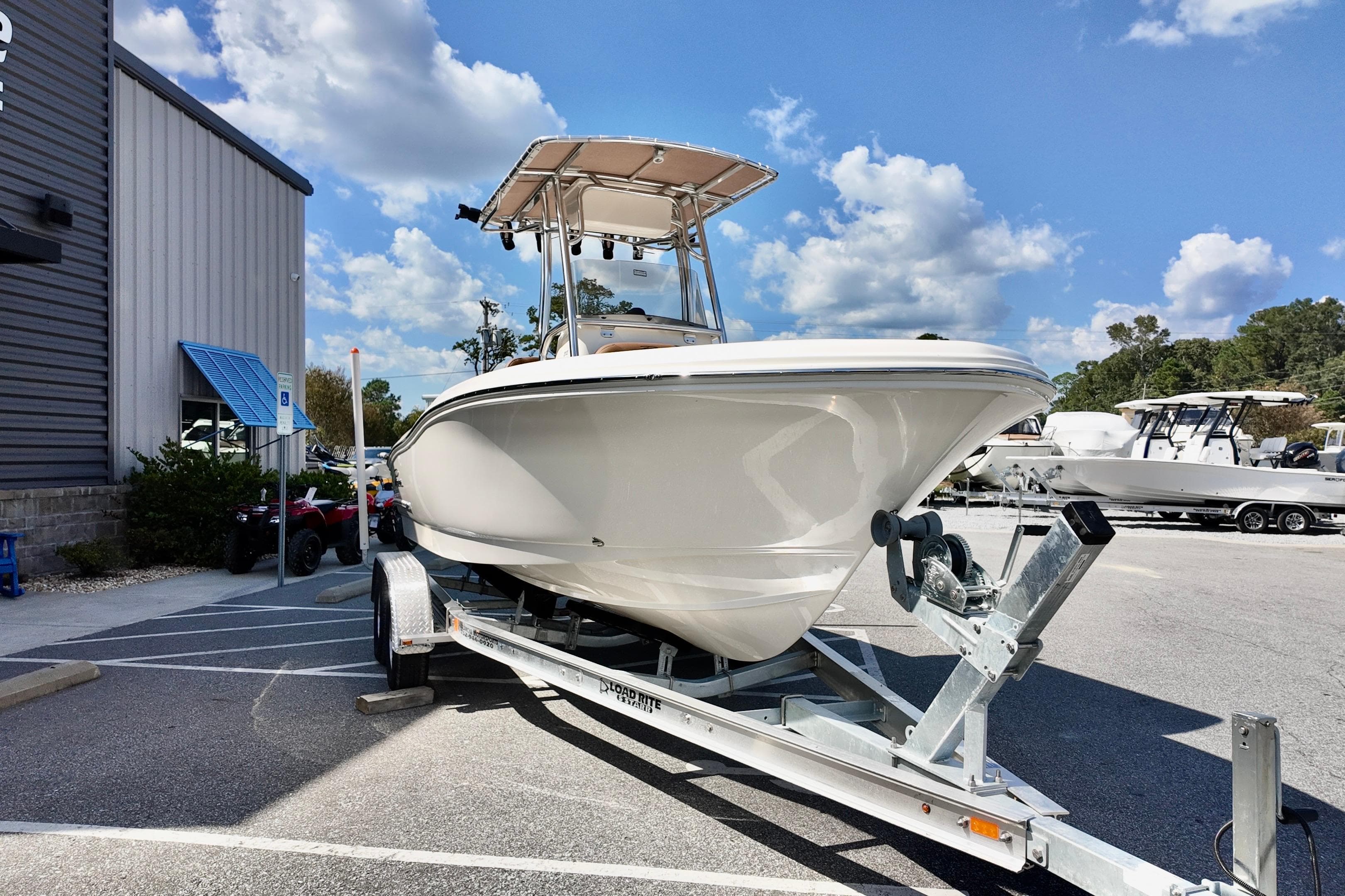 2026 Pioneer 202 Sportfish boat on trailer under a sunny sky.