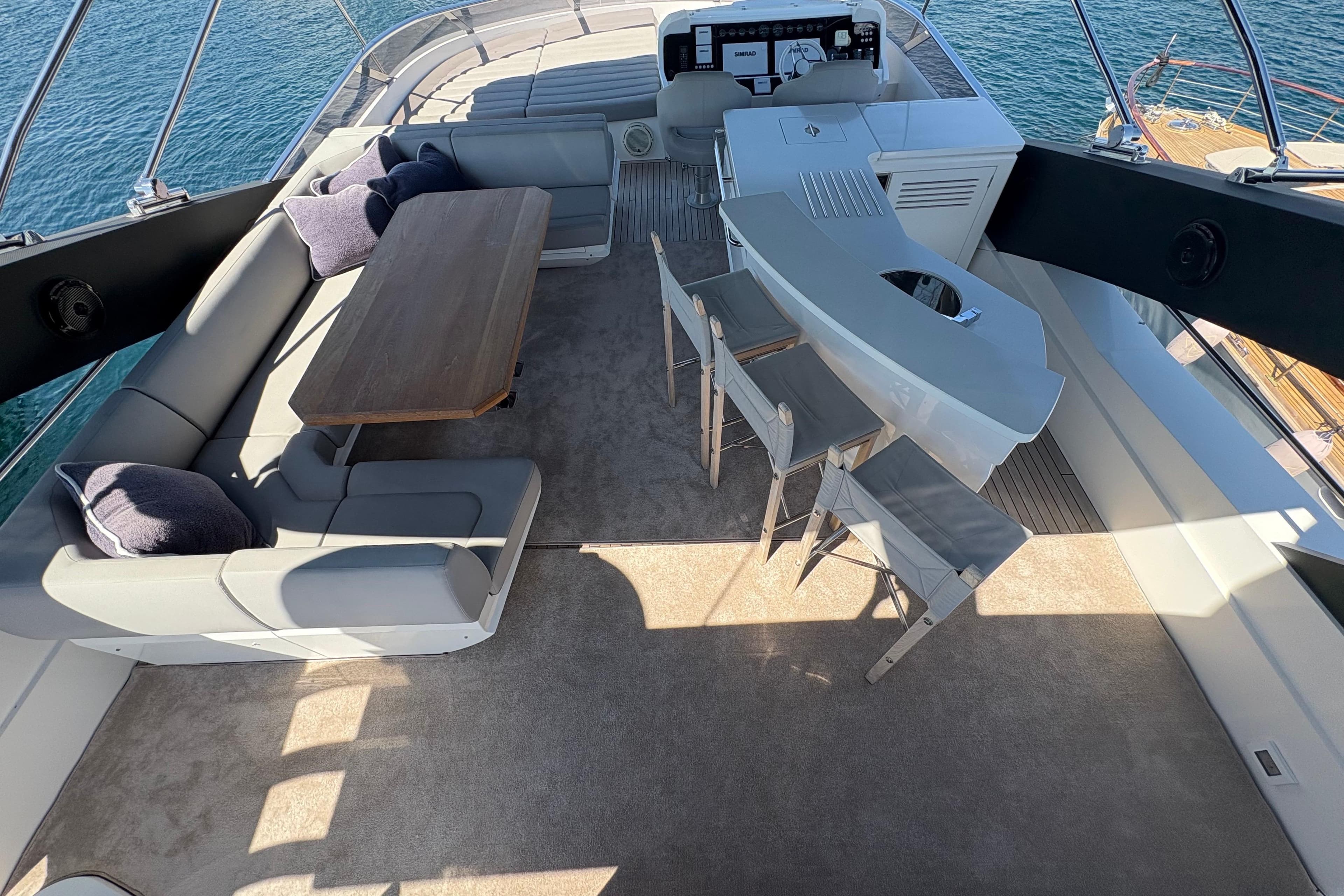 Luxurious 2018 Sunseeker 86 Yacht flybridge with seating, bar, and ocean view.