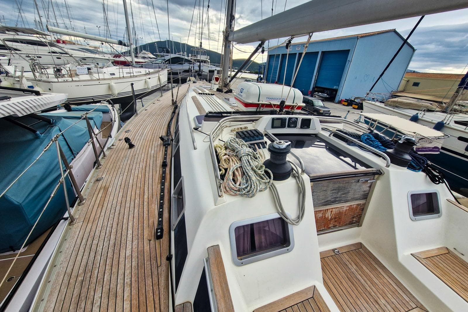 Sailboat deck of 2002 Nautor Swan 44, featuring ropes and winches in a marina setting.