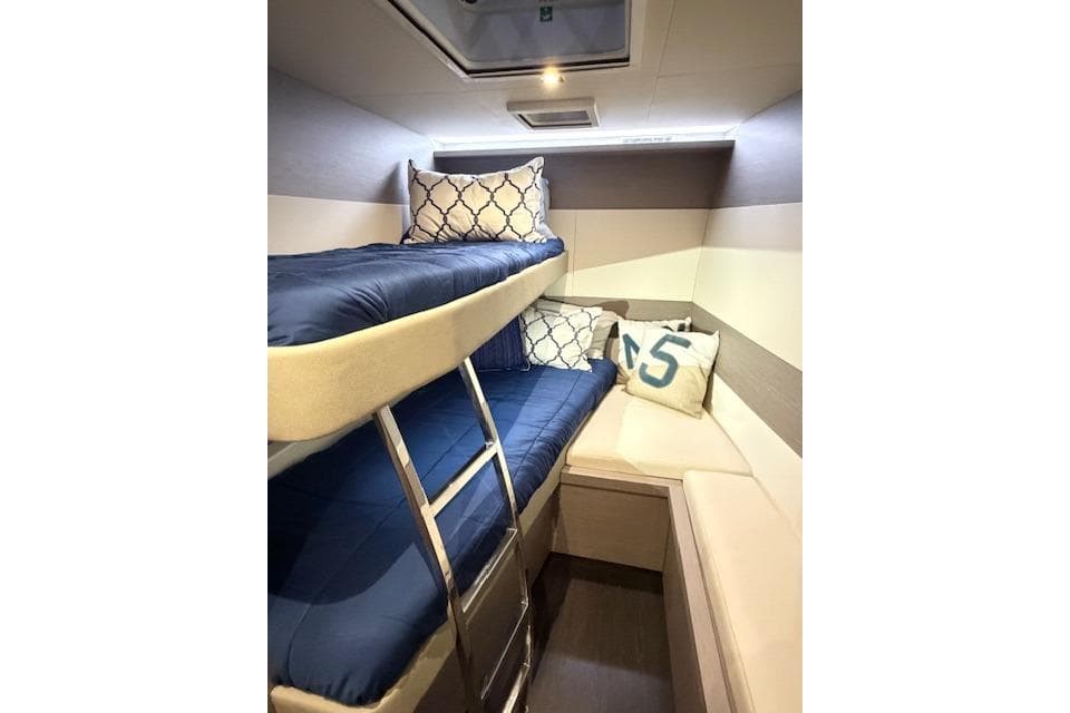 2024 Fountaine Pajot MY5 cabin with bunk beds and cozy seating area.