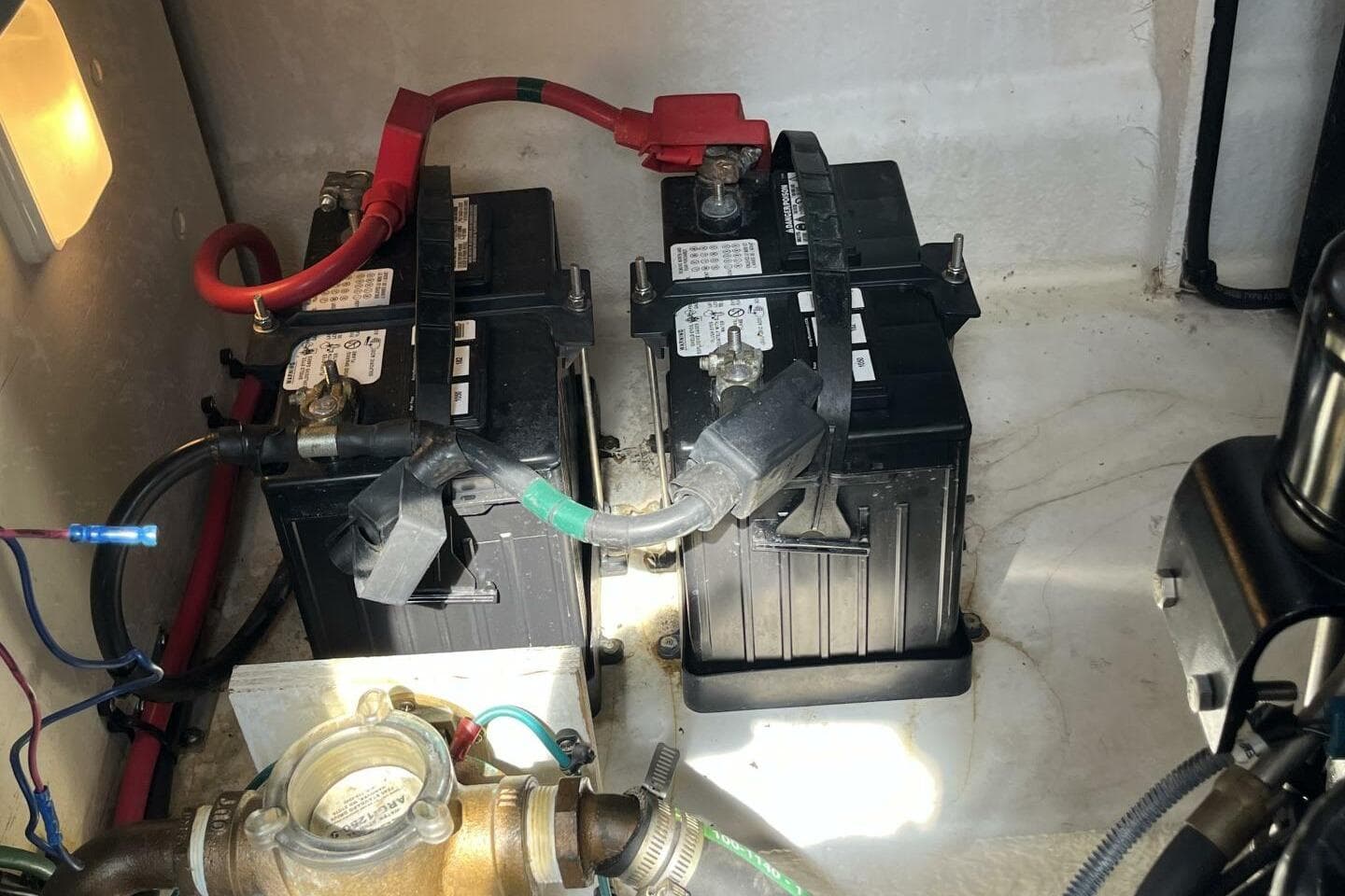 Battery compartment of a 2007 Sea Ray 340 Sundancer boat, showing two batteries and wiring.