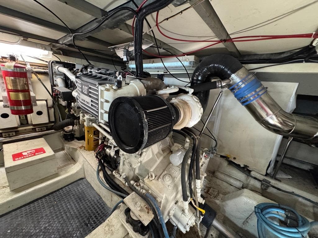 Engine room of 1989 Birchwood 62 Cockpit Motor Yacht, featuring CAT engine and fire extinguisher.