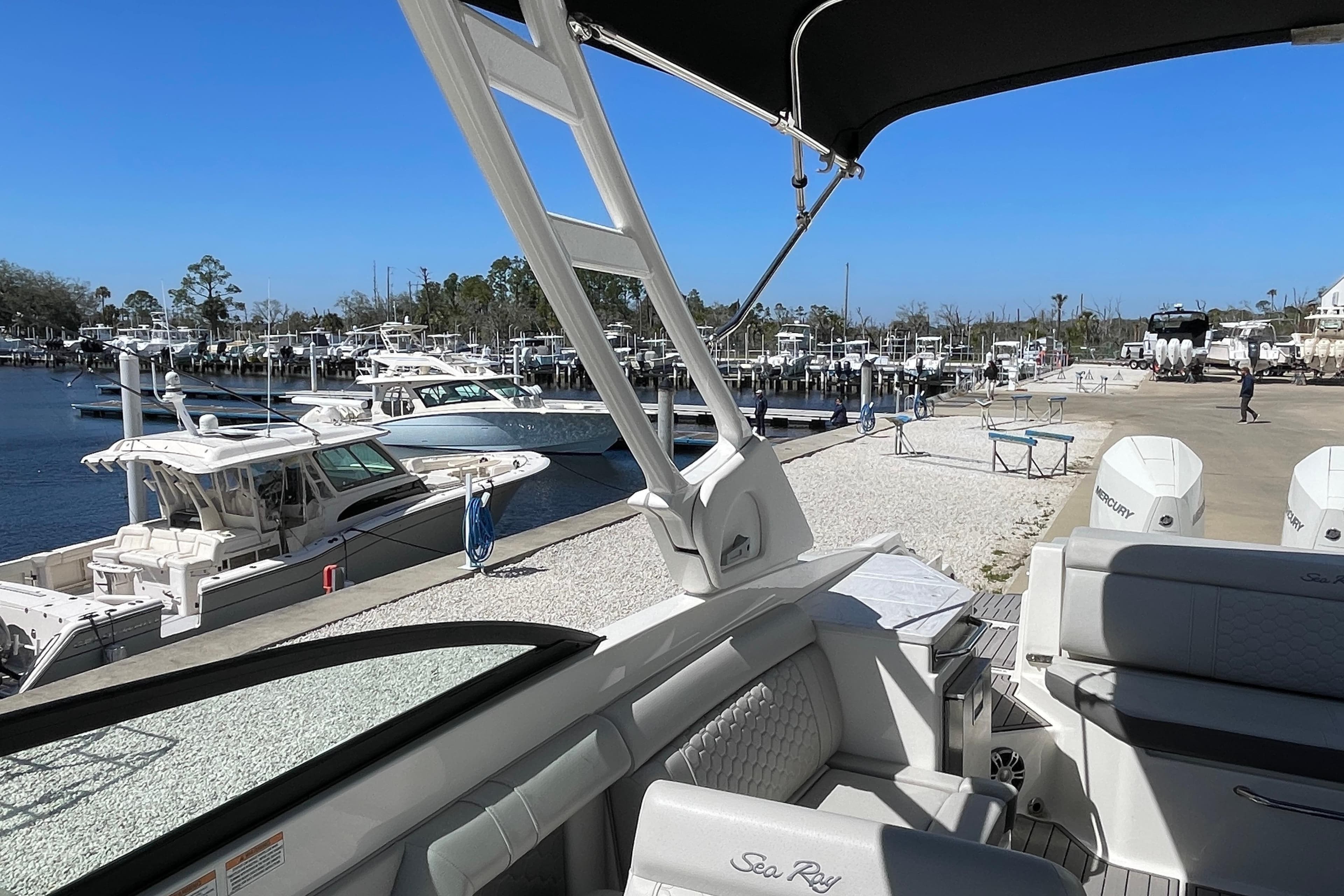 2023 Sea Ray SDX 290 Outboard at marina, showcasing luxury seating and scenic waterfront.