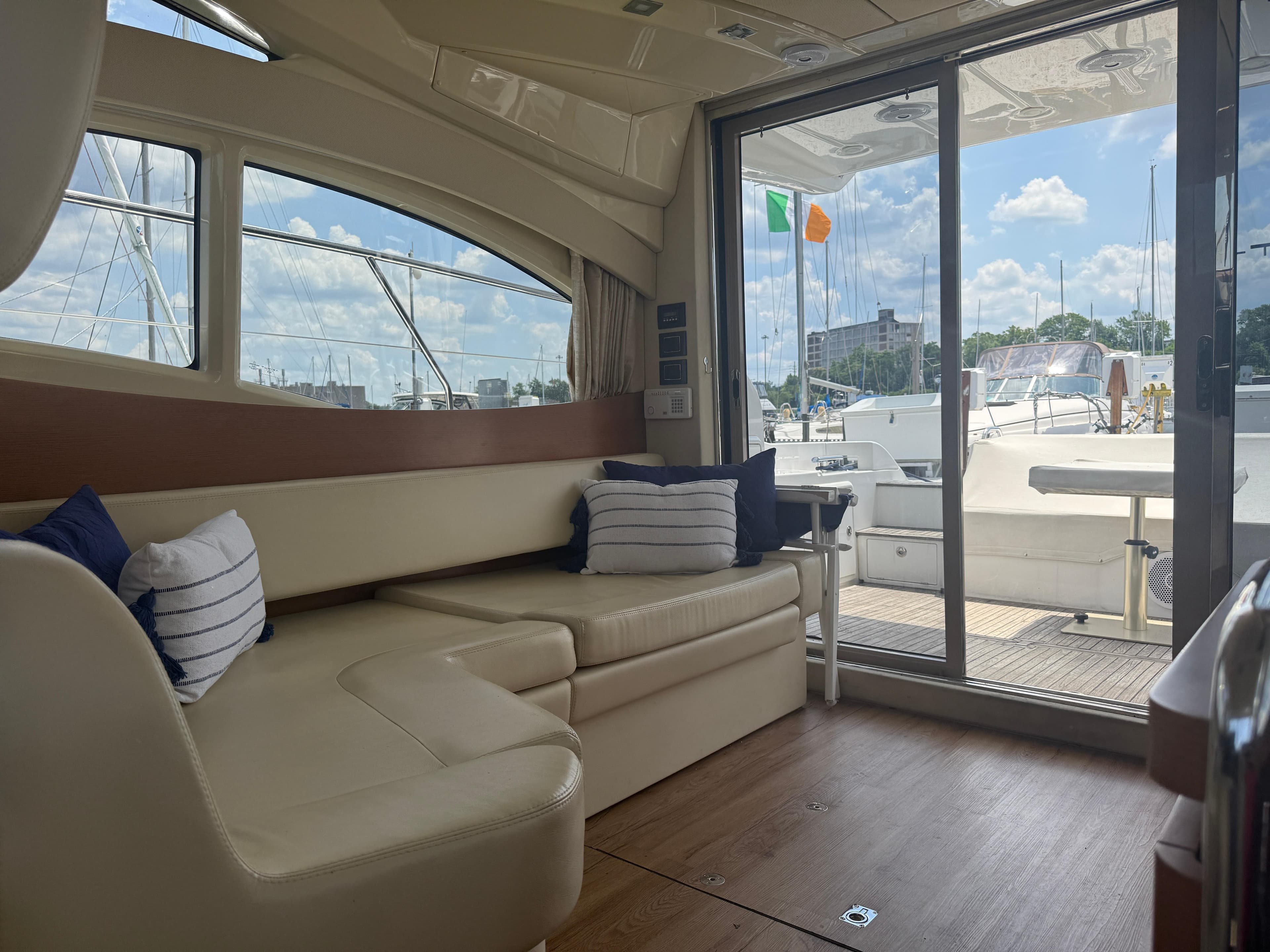 Luxurious interior of 2018 Azimut 42 Fly yacht with plush seating and scenic marina view.