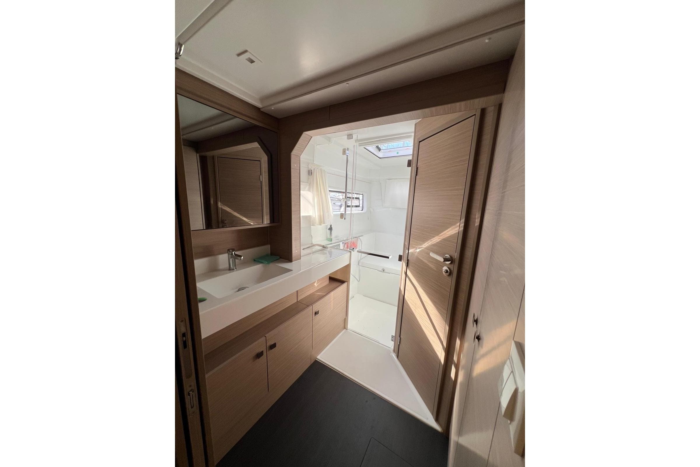 Modern bathroom interior of 2026 Lagoon 43 yacht, featuring sleek design and ample natural light.