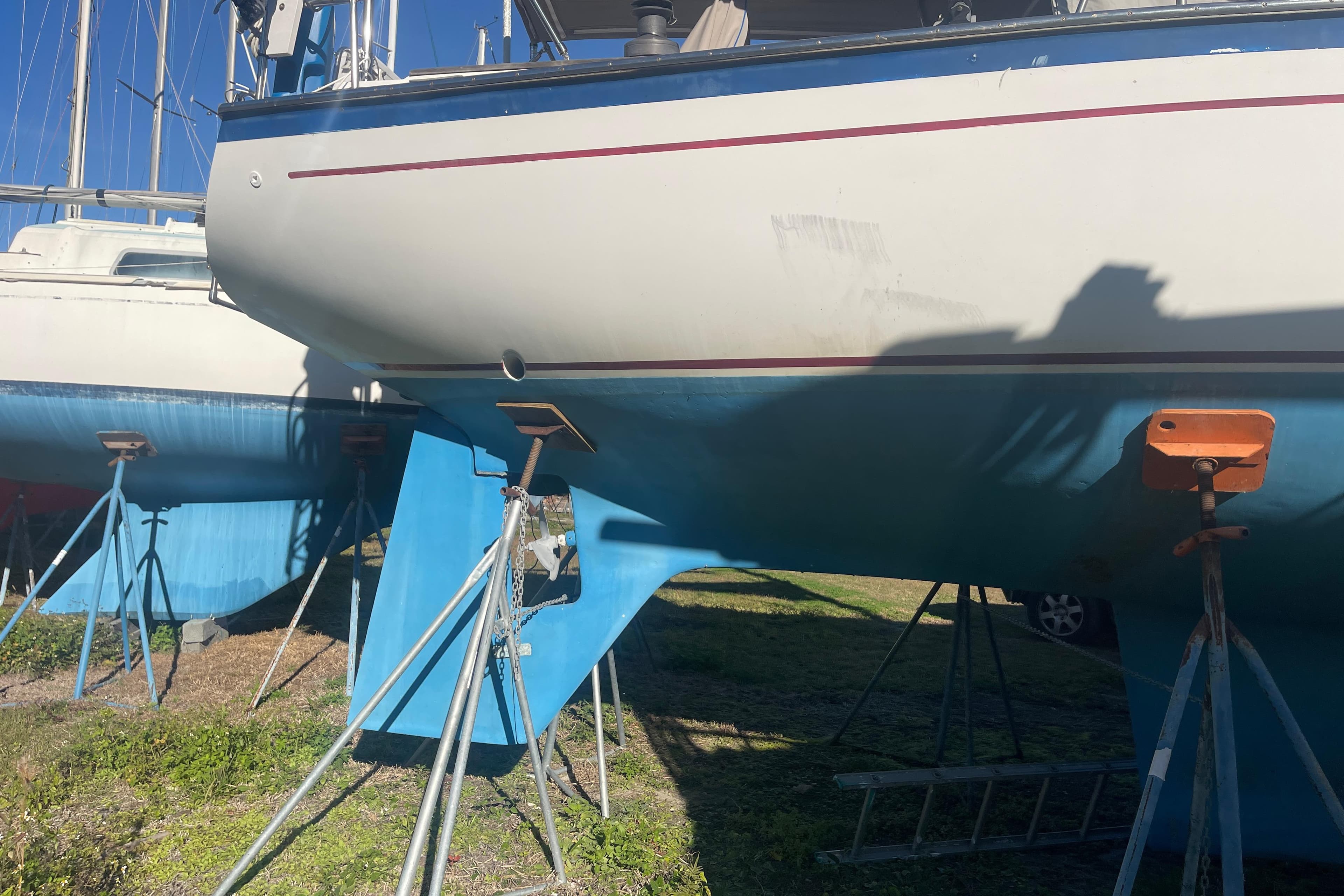 1984 Morgan 384 sailboat on stands, blue hull, white top, sunny day.