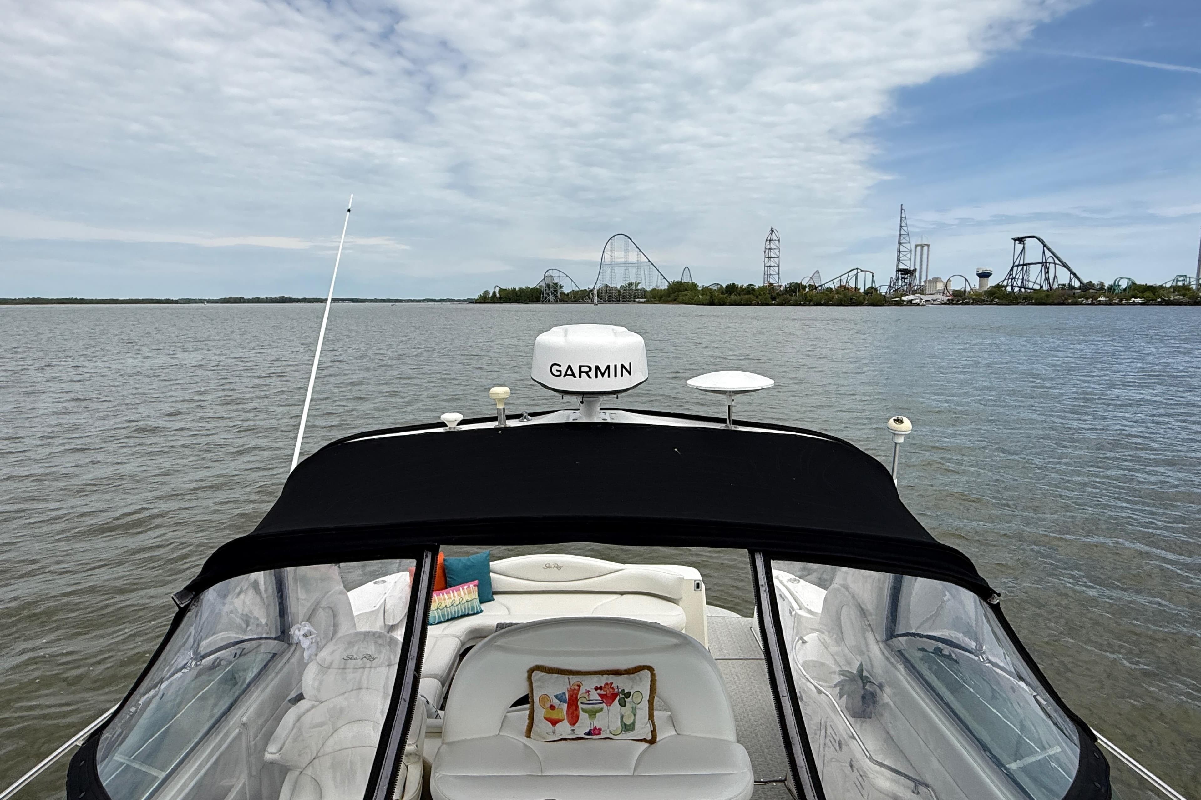 Sea Ray 410 Sundancer 2000 yacht cruising near amusement park skyline.