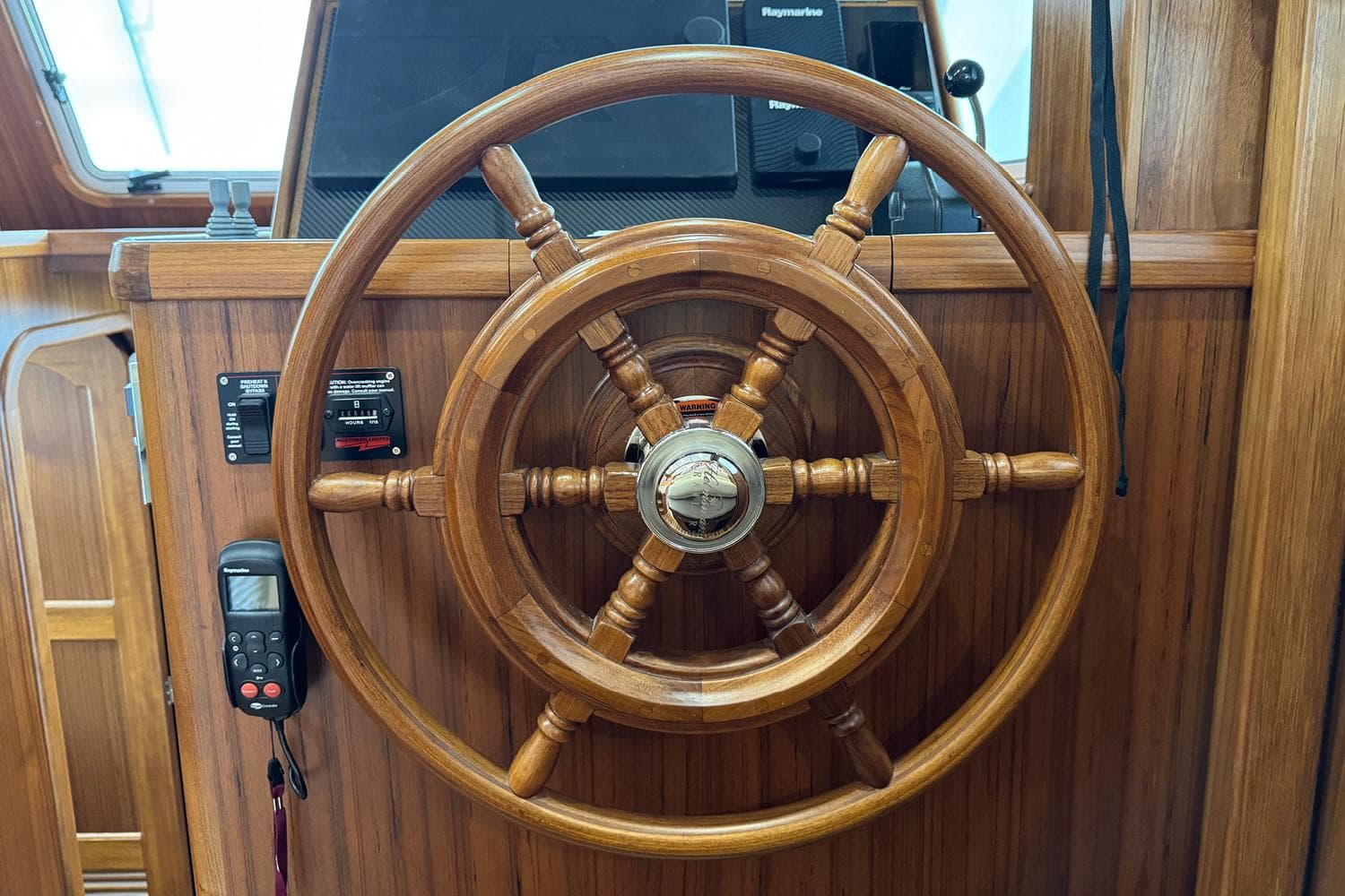 Wooden helm of 2026 Helmsman Trawlers 38 Sedan, featuring classic nautical design.