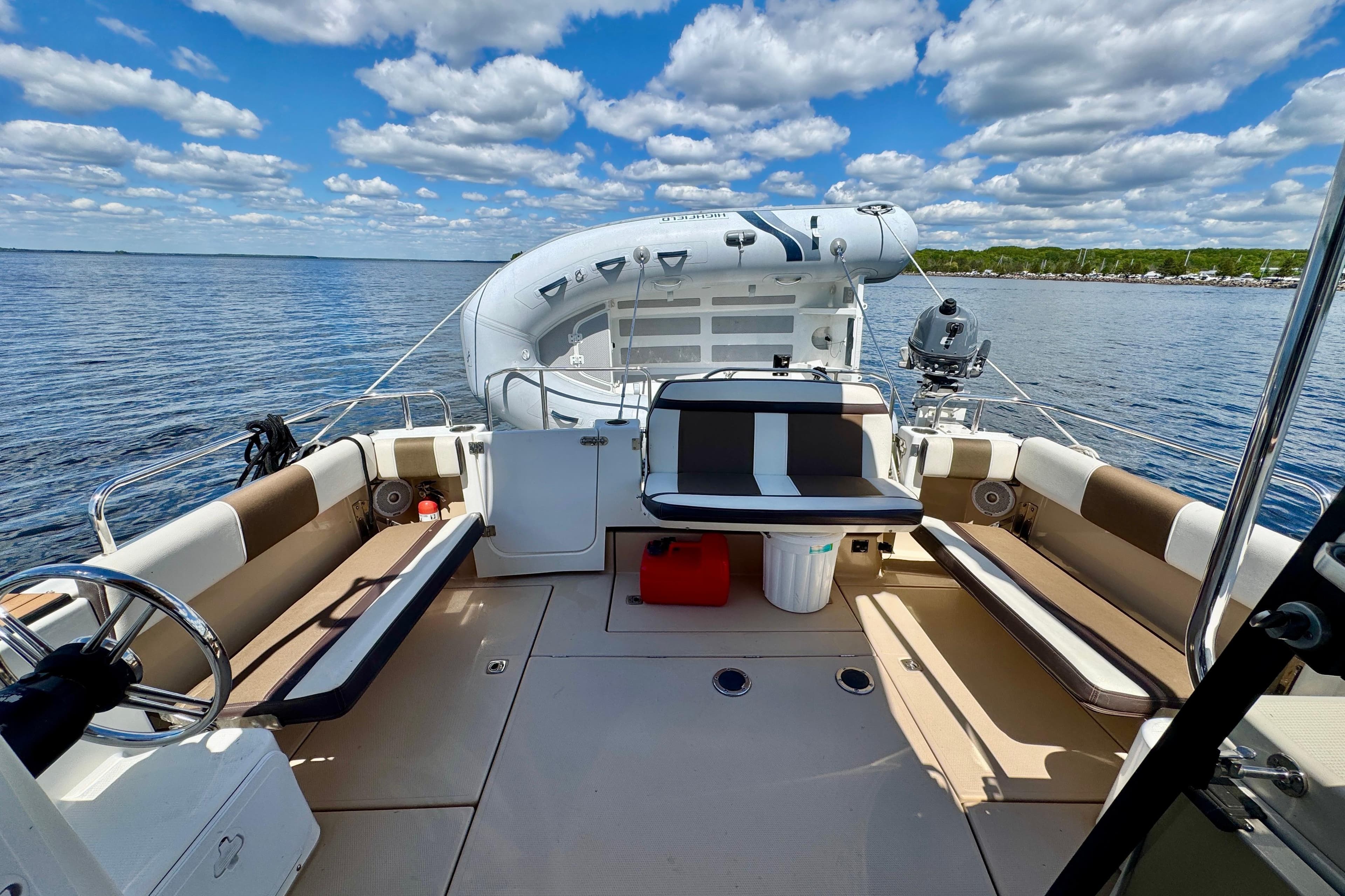 2017 Ranger Tugs R-29 CB boat interior with seating, steering wheel, and inflatable dinghy.