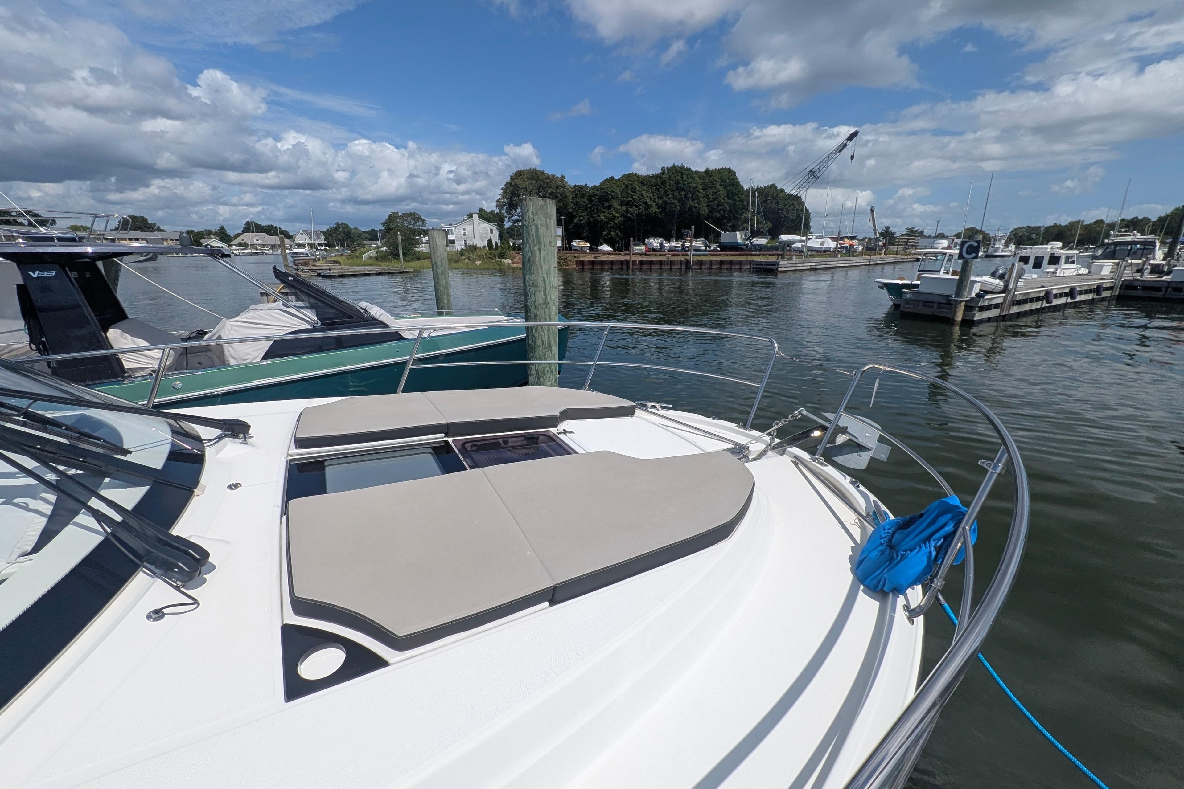 2023 Jeanneau NC Weekender 1095 docked at a marina under a partly cloudy sky.