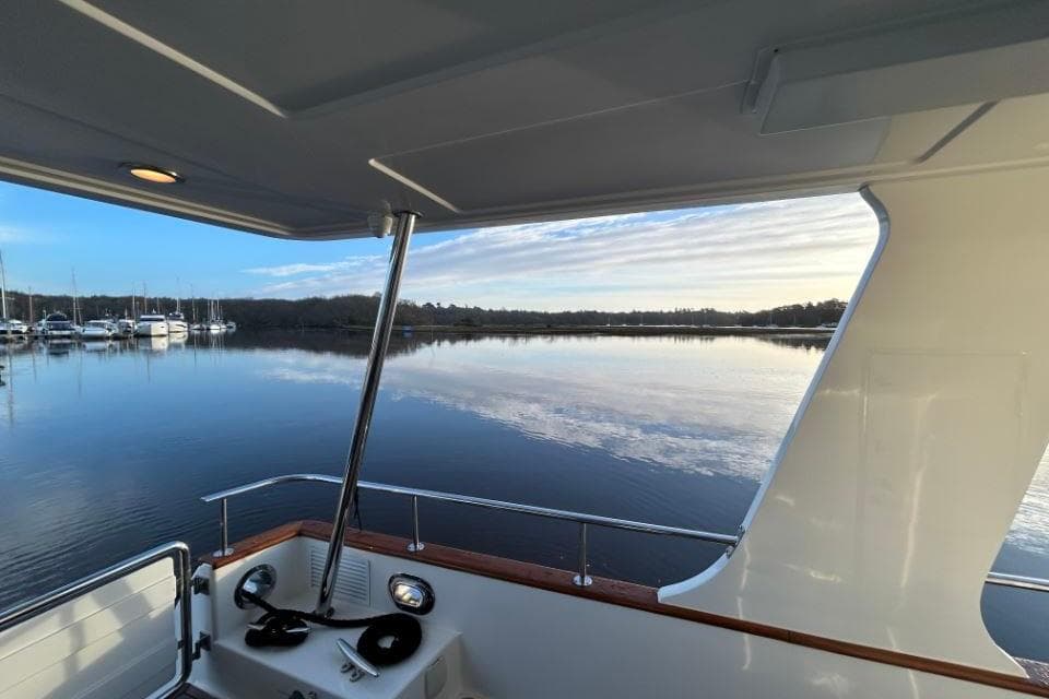 2008 Grand Banks 59 Aleutian RP yacht on serene water with marina view.