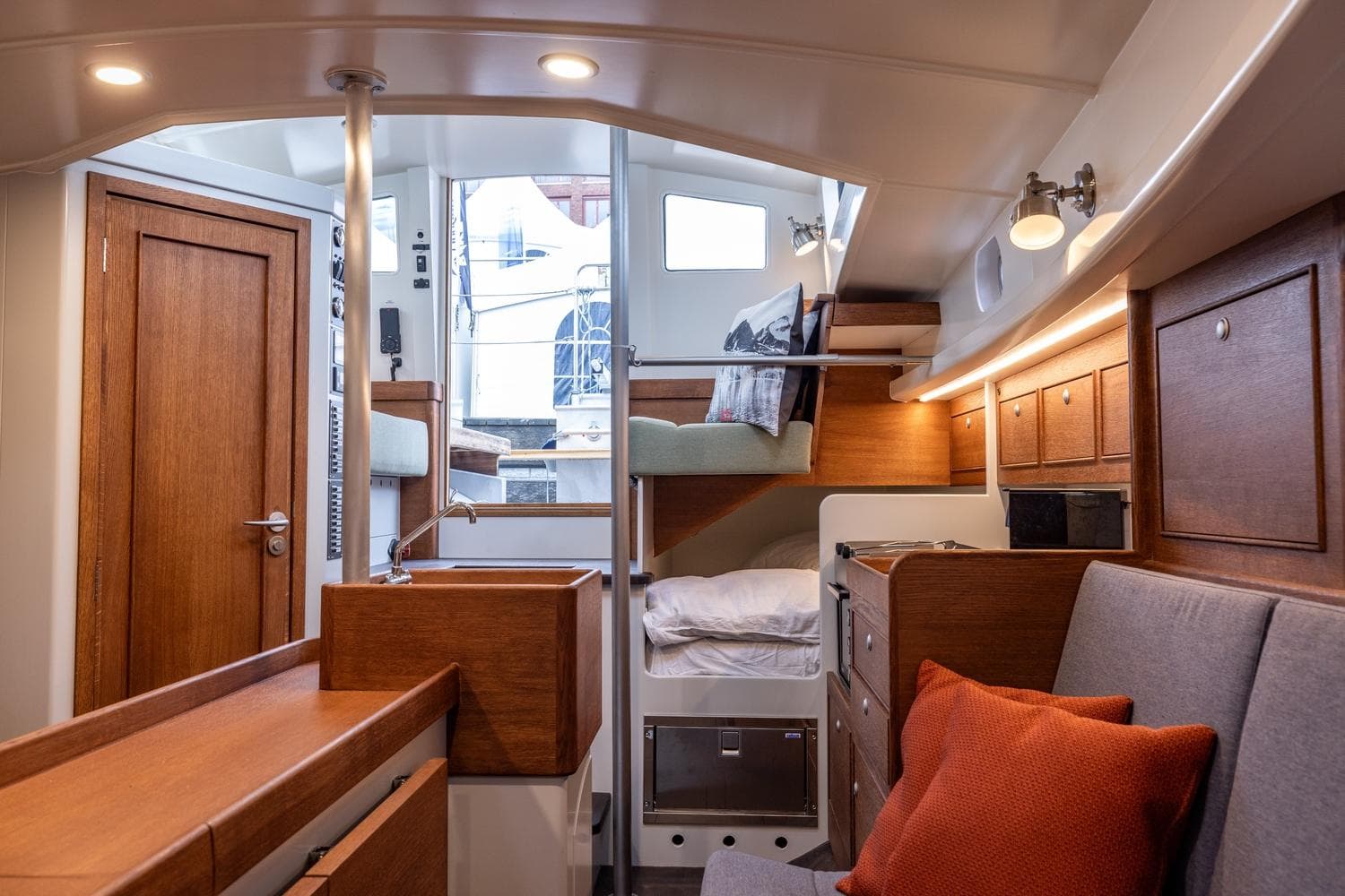 Interior of 2023 Bestevaer 36 yacht, featuring cozy seating, wooden cabinetry, and modern lighting.