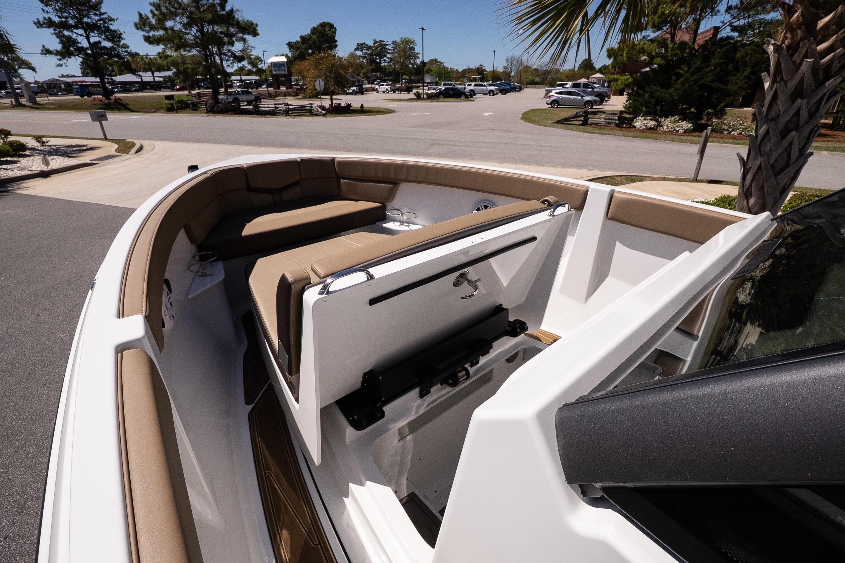 2026 Monterey Elite 25 OB boat with tan seating and sleek design in a sunny setting.