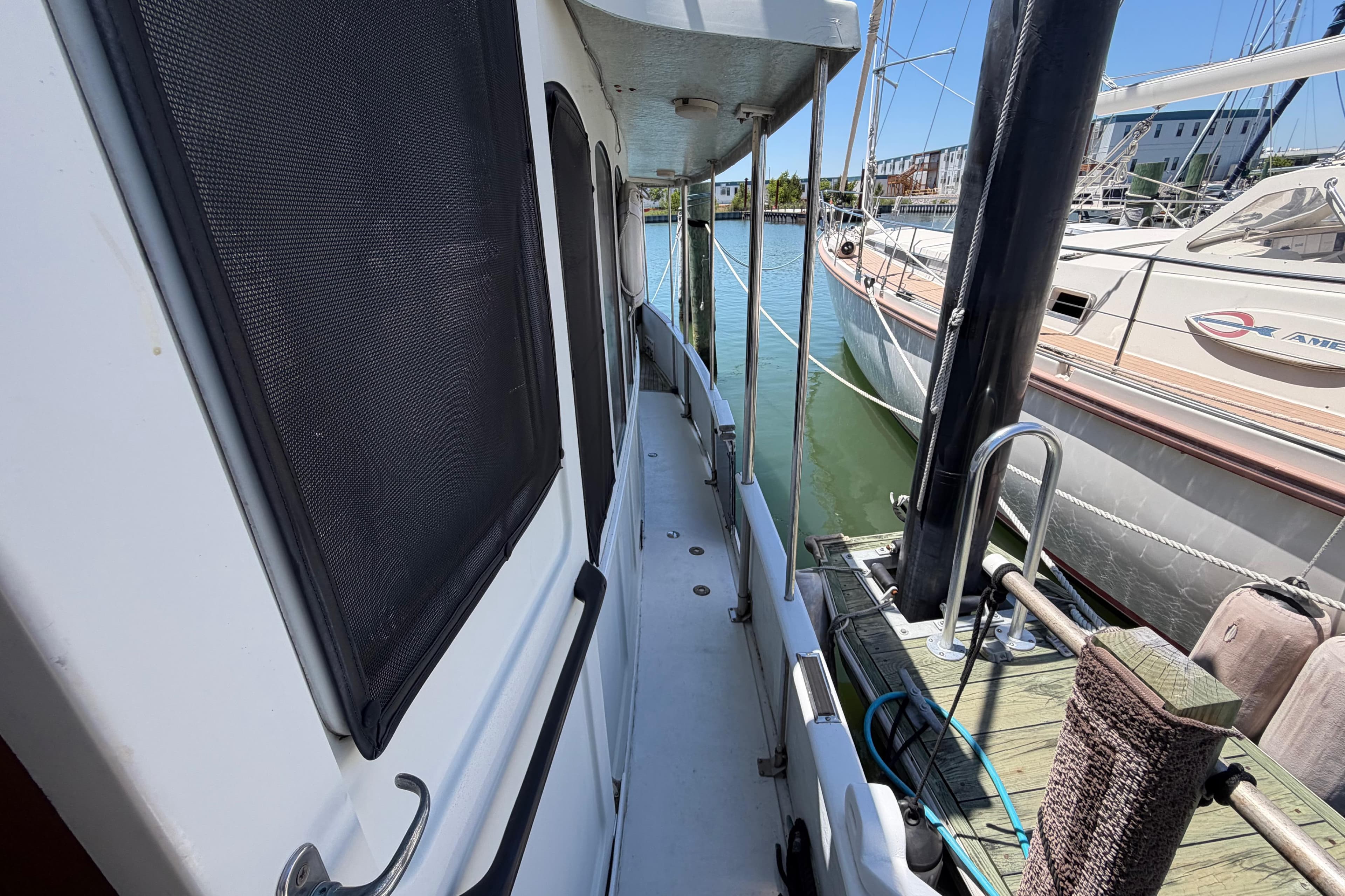 Side deck view of 1985 Gozzard PILGRIM yacht docked at marina.