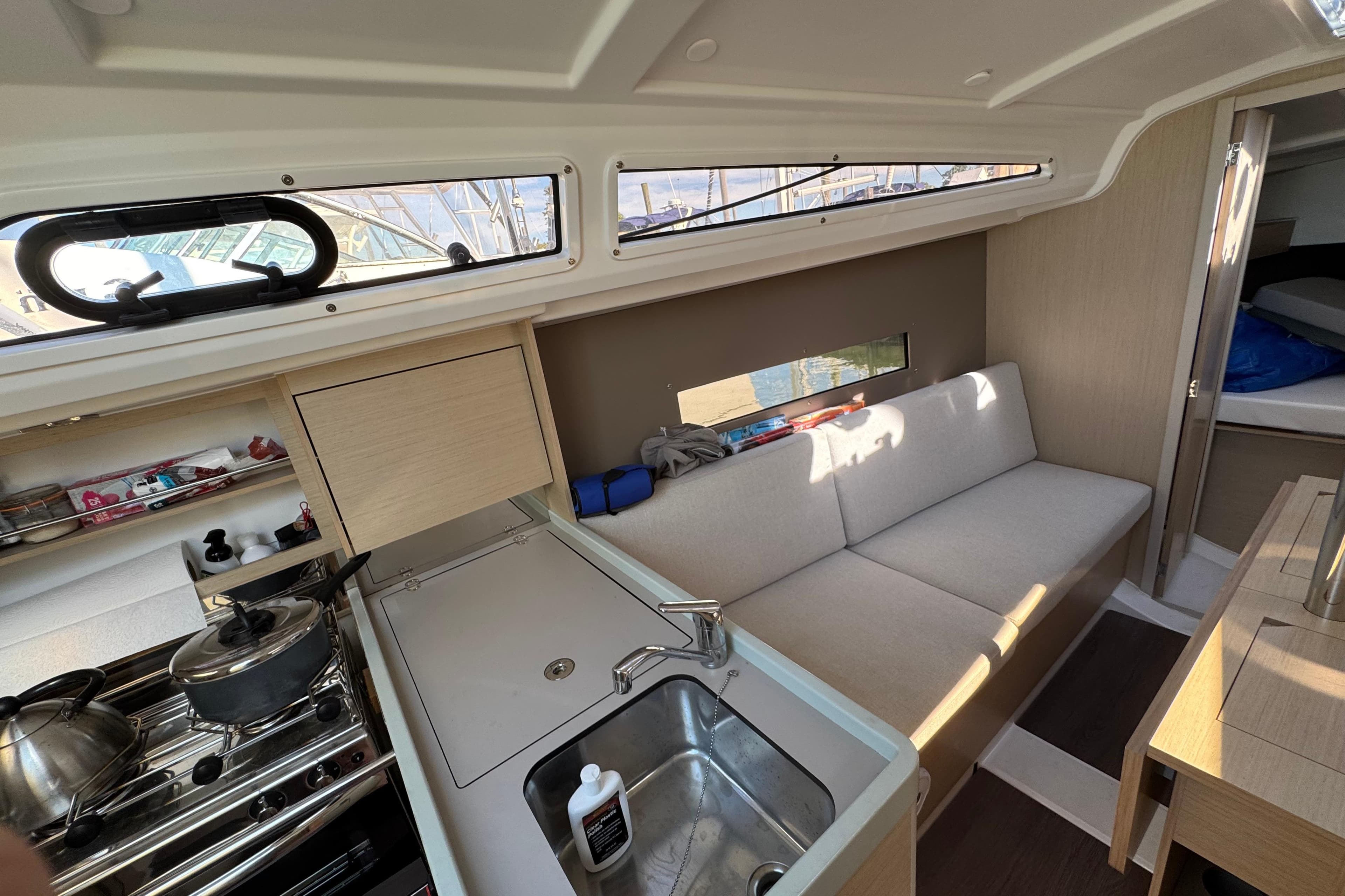 Interior of 2020 Beneteau Oceanis 30.1 yacht, featuring a compact kitchen and cozy seating area.
