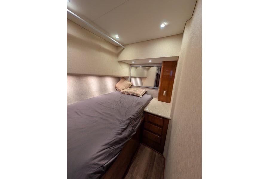 Interior cabin of 2005 Egg Harbor 43 SportYacht with bed and storage drawers.
