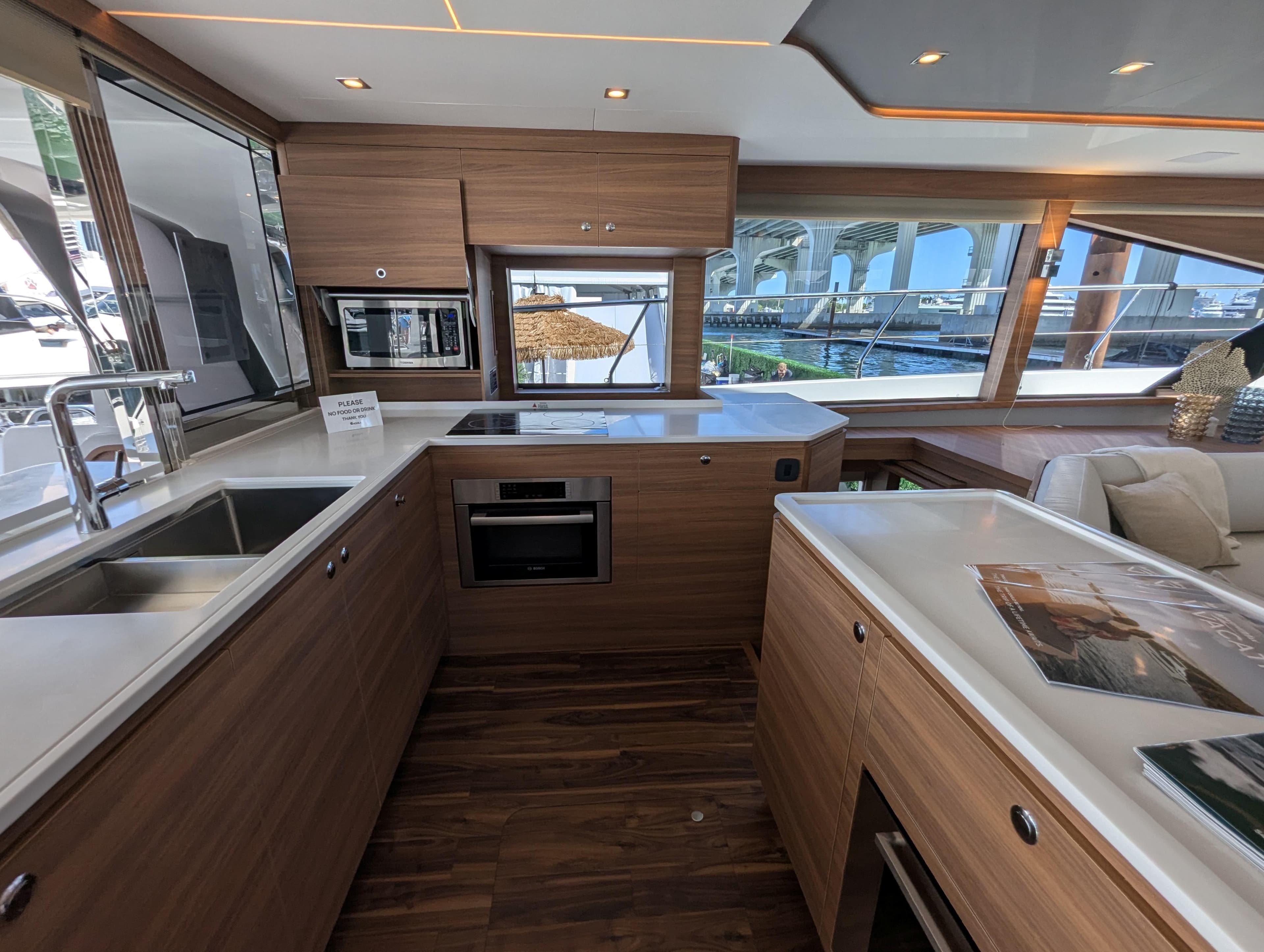 Luxurious interior of 2025 Aquila 54 Yacht with modern kitchen and scenic window views.