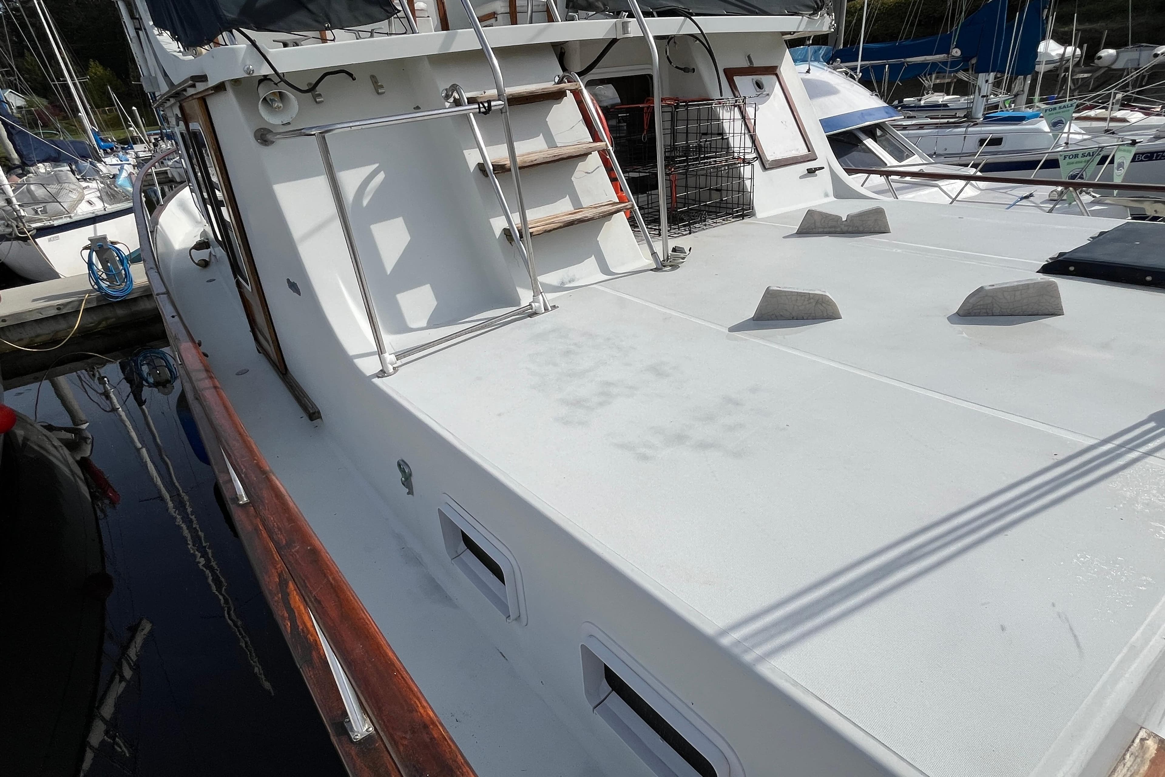 1974 DeFever 40 yacht deck with clean white surface and marina background.