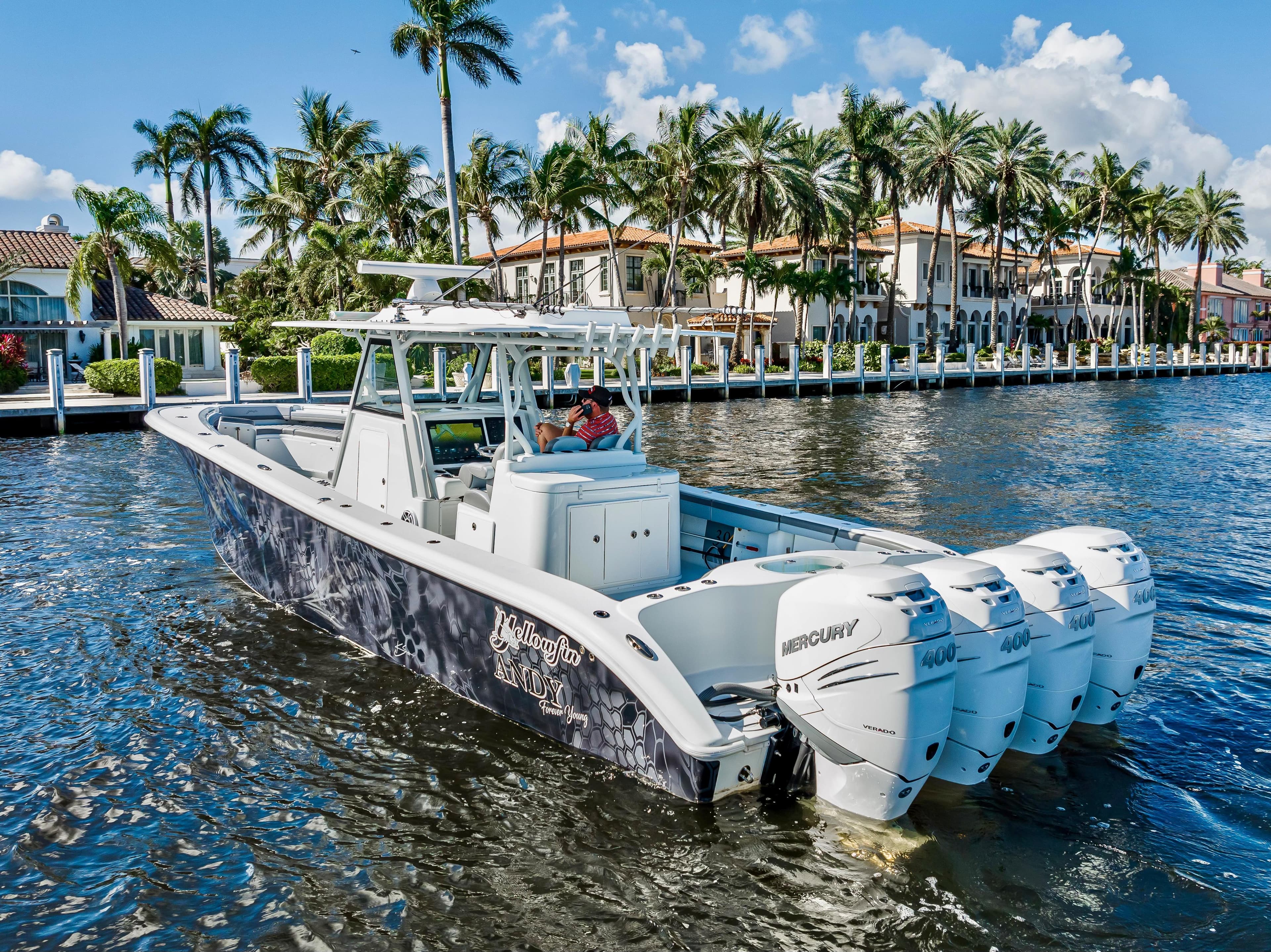 2021 Yellowfin 39 boat cruising on a sunny waterfront with palm trees.