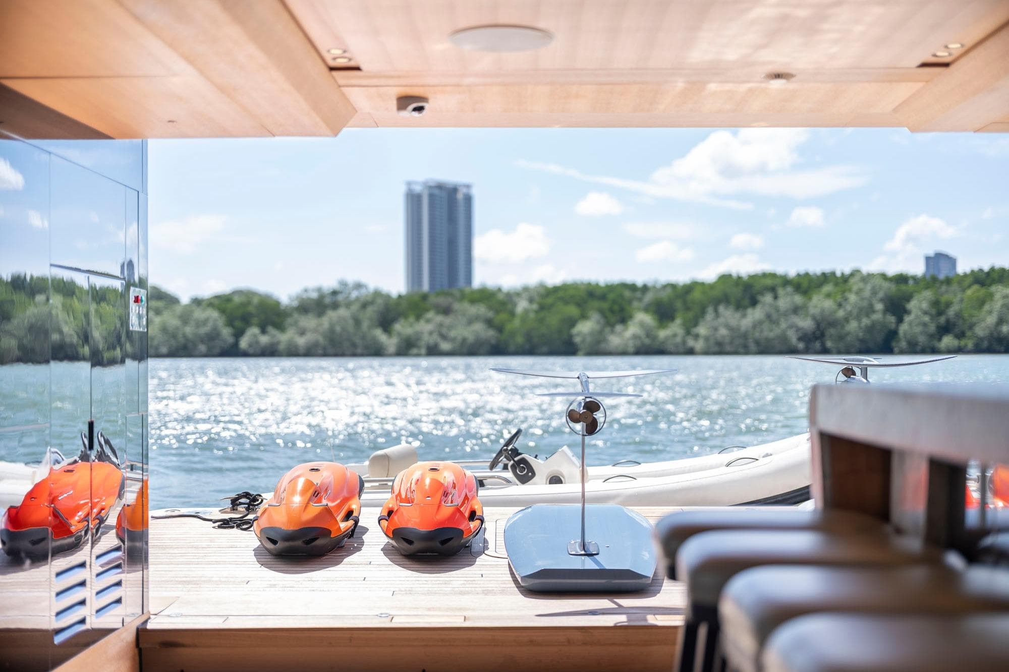 Luxurious 2021 Sanlorenzo 44 Alloy yacht deck with water sports equipment and scenic river view.