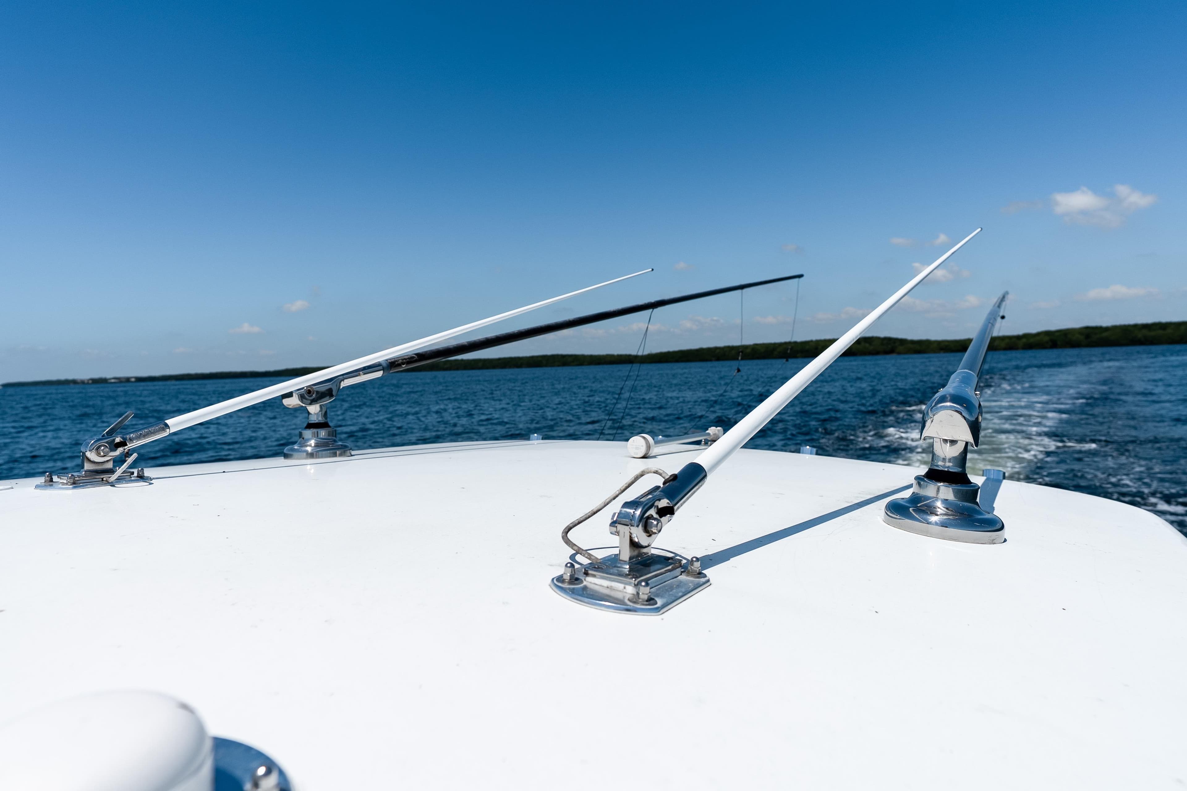2022 Contender 35 ST boat with fishing outriggers on open water under clear blue sky.