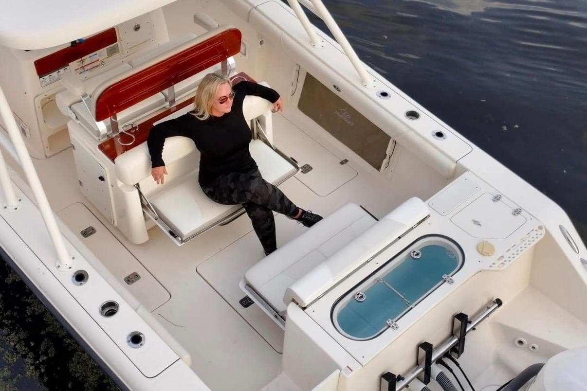 Woman relaxing on a 2014 Pursuit S 280 Sport boat, enjoying the open deck.
