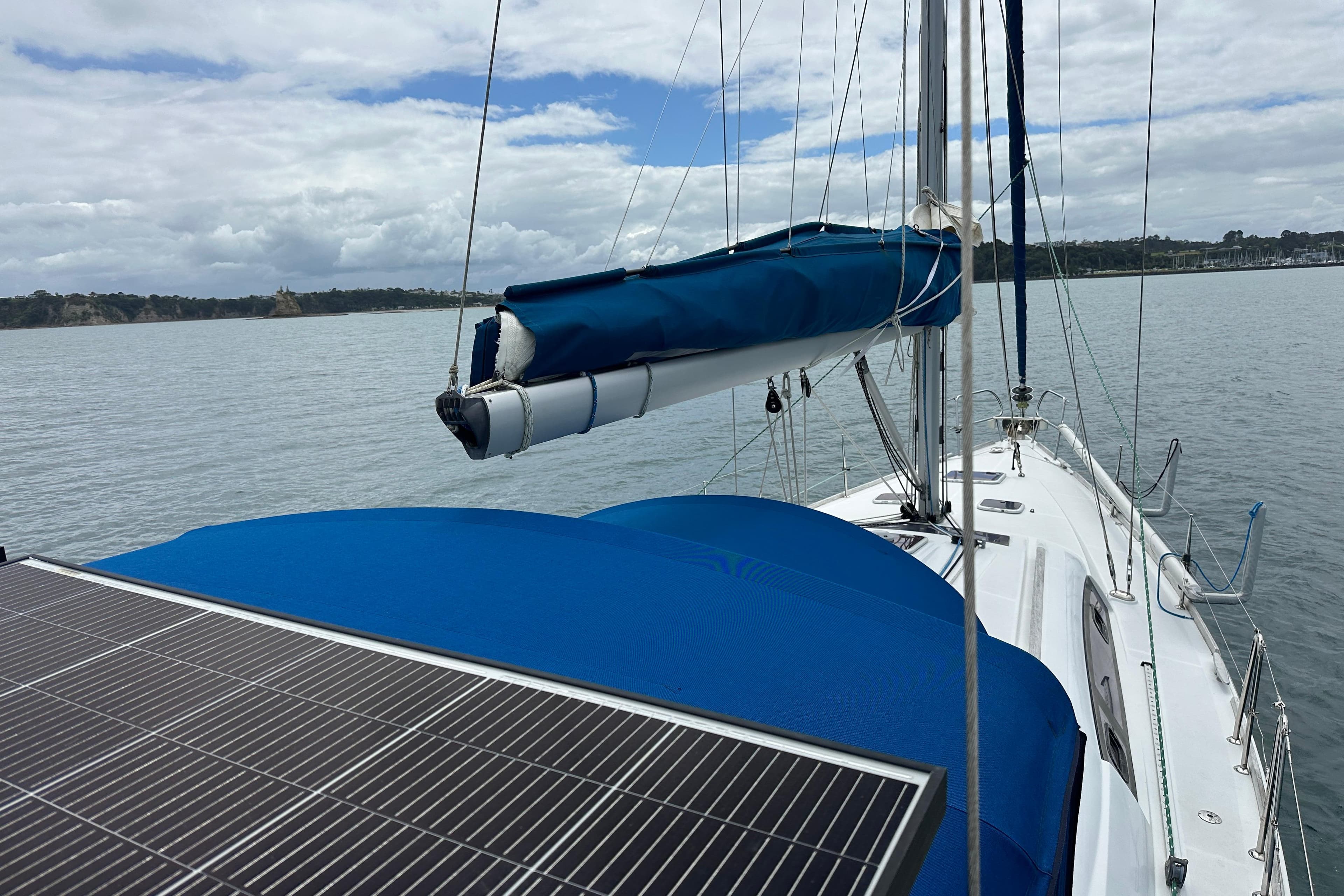 2009 Beneteau Oceanis 43 sailboat with solar panels on deck, anchored in calm waters.
