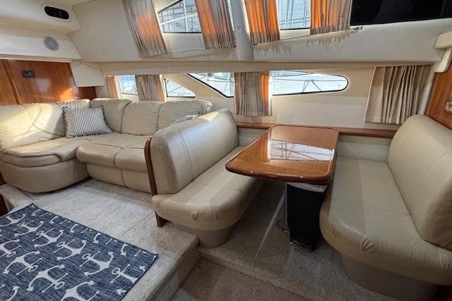 Interior of 2006 Carver 36 Motor Yacht with beige seating and wooden table.