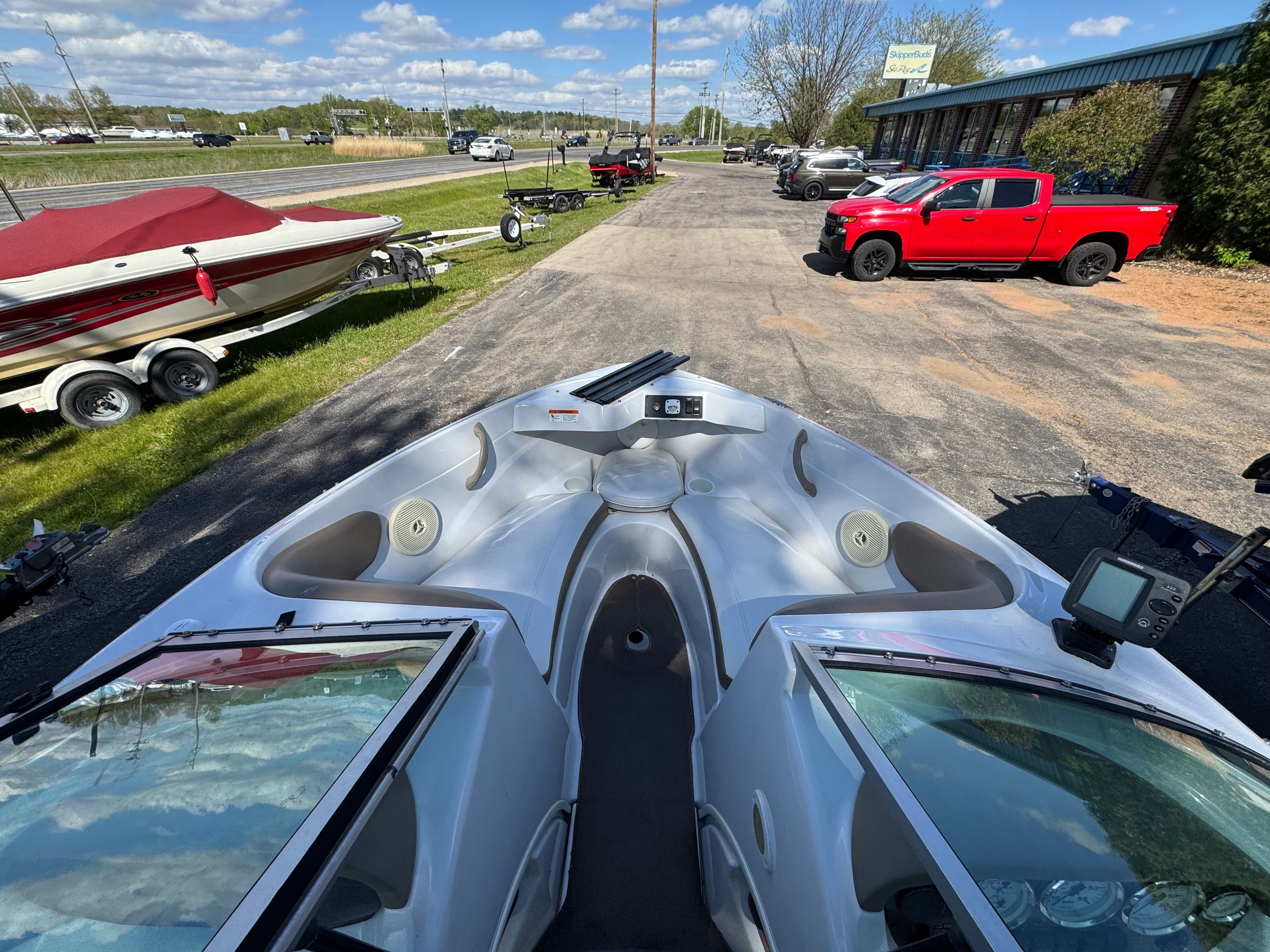 2008 Four Winns 183 Horizon FS boat on parking lot with trailers.