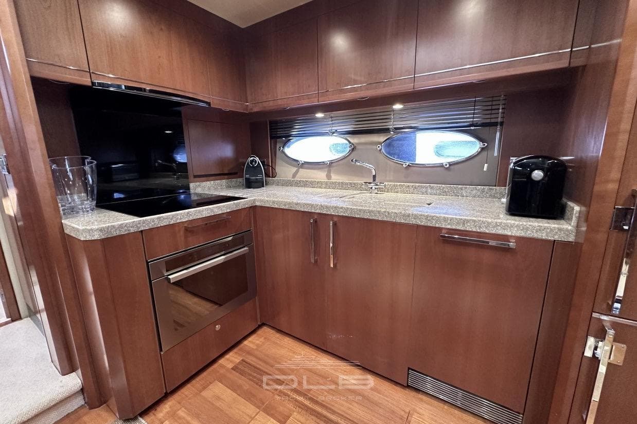 Luxurious 2006 Princess V70 yacht kitchen with modern appliances and elegant wood cabinetry.